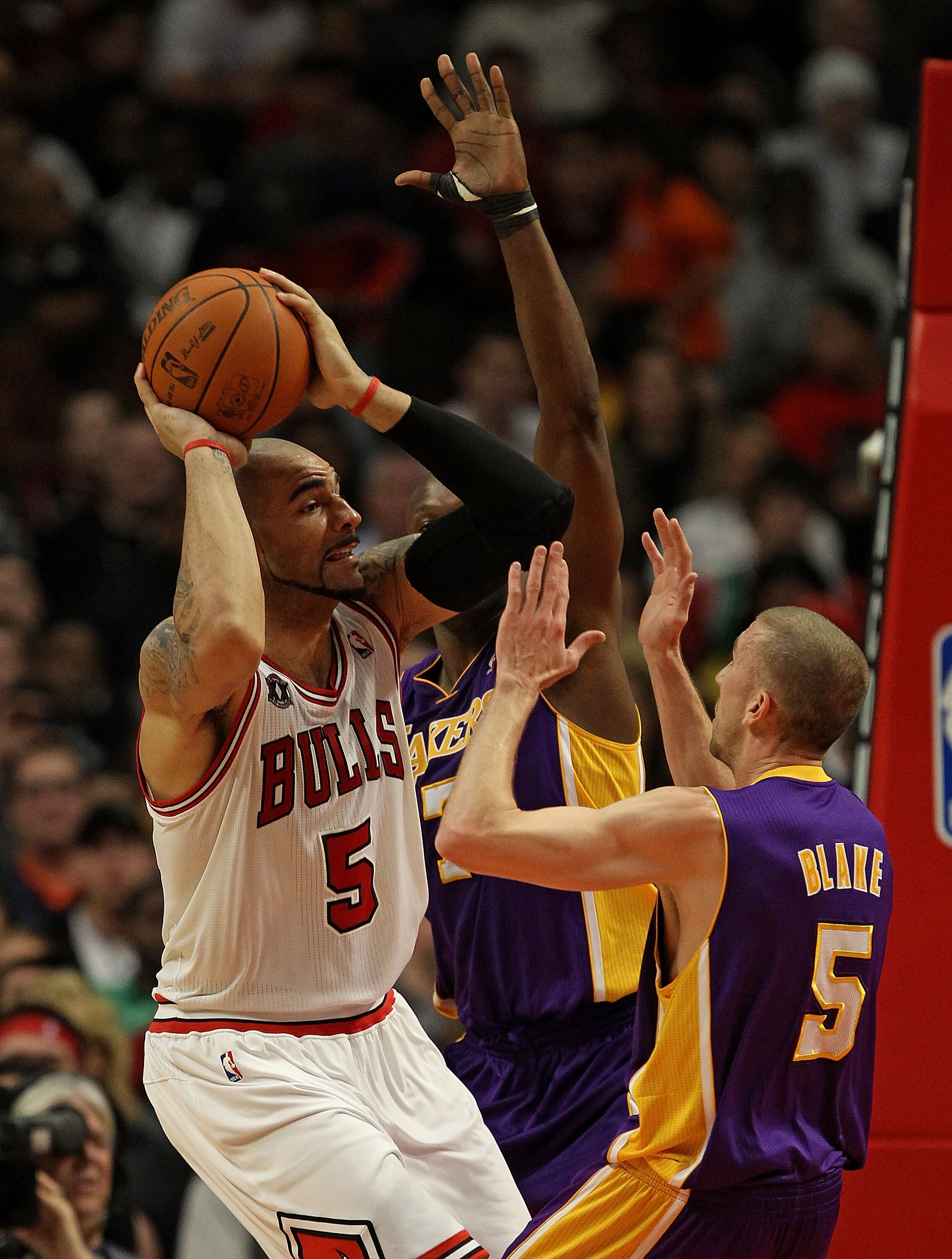 CHICAGO, IL - DECEMBER 10: Carlos Boozer #5 of the Chicago Bulls looks to pass under pressure from Lamar Odom #7 and Steve Blake #5 of the Los Angeles Lakers at the United Center on December 10, 2010 in Chicago, Illinois. NOTE TO USER: User expressly ackn