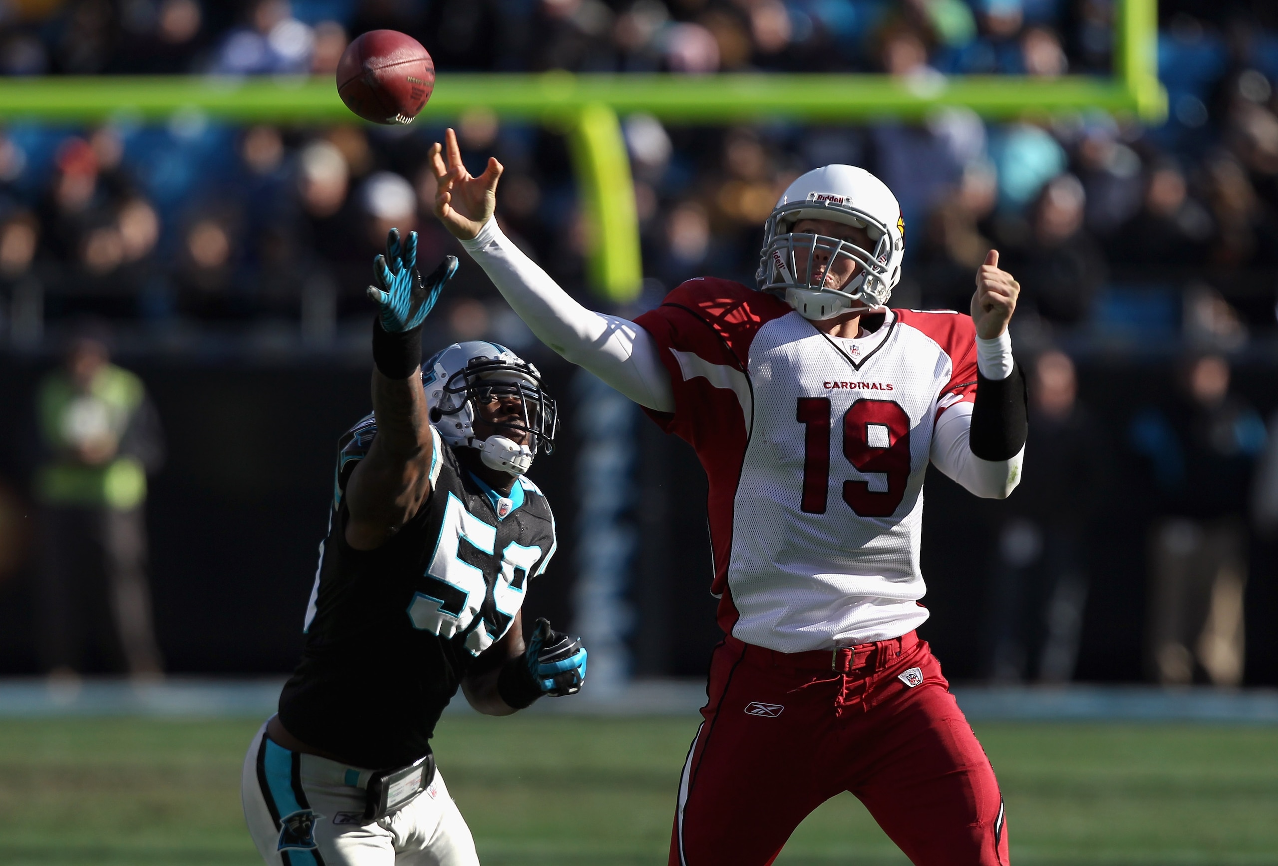 CHARLOTTE, NC - DECEMBER 19:  John Skelton #19 of the Arizona Cardinals runs away from Nic Harris #59 of the Carolina Panthers during their game at Bank of America Stadium on December 19, 2010 in Charlotte, North Carolina.  (Photo by Streeter Lecka/Getty