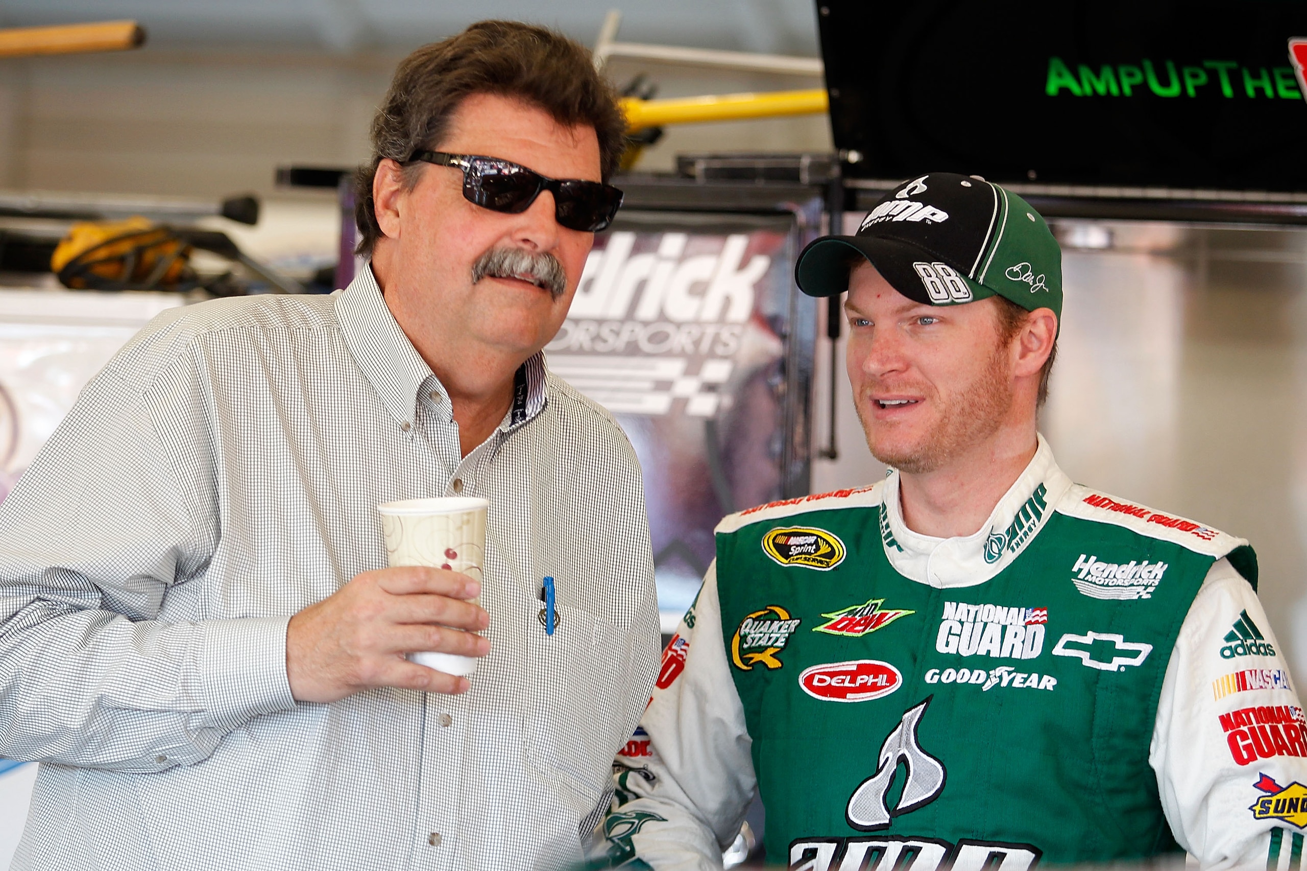 FONTANA, CA - OCTOBER 09:  Dale Earnhardt Jr., driver of the #88 National Guard/AMP Energy Chevrolet, stands in the garage with NASCAR President Mike Helton during practice for the NASCAR Sprint Cup Series Pepsi Max 400 on October 9, 2010 in Fontana, Cali