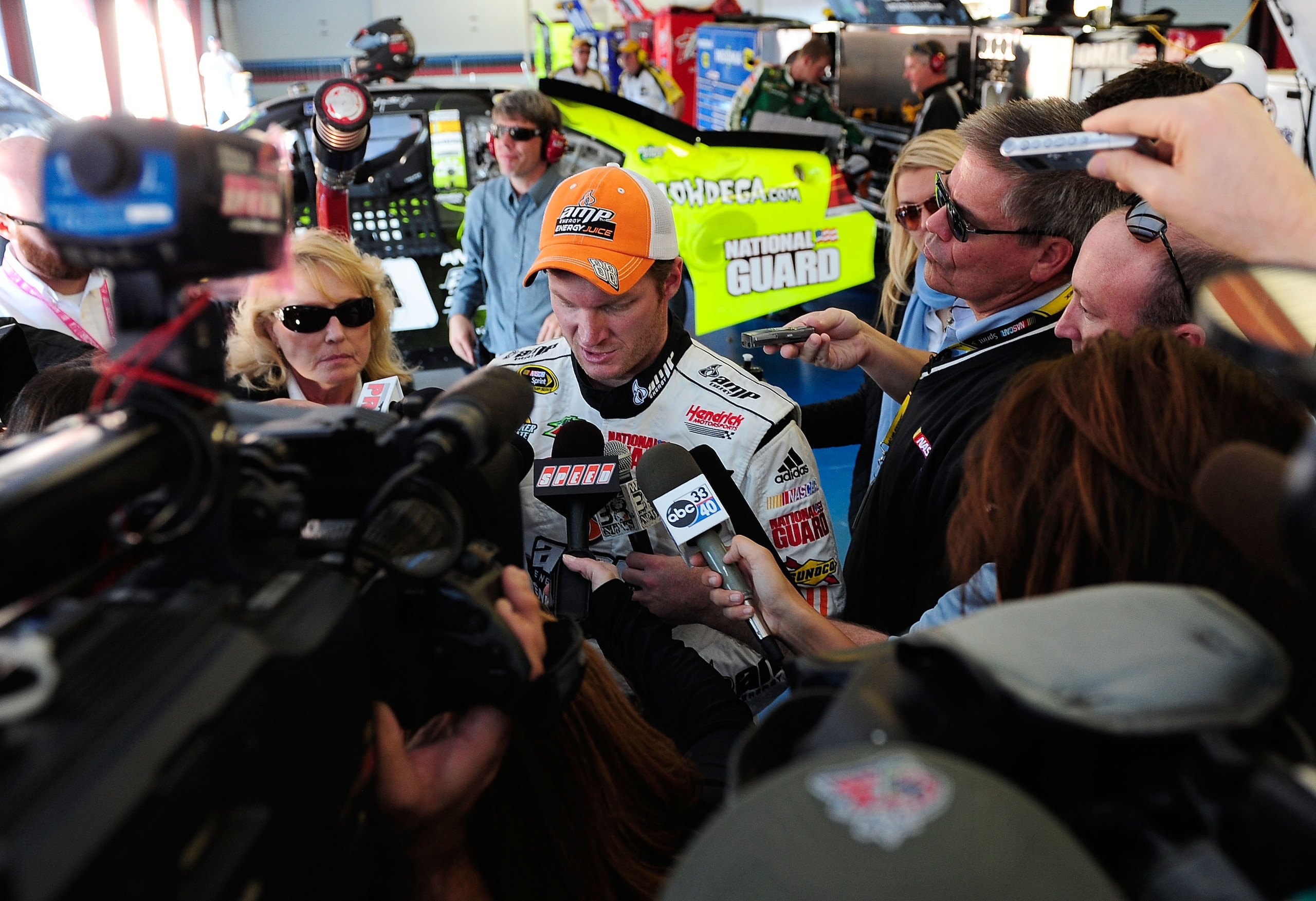 TALLADEGA, AL - OCTOBER 31:  Dale Earnhardt Jr. (C), driver of the #88 LegendofHallowdega.com/AMP Energy Juice/National Guard Chevrolet, speaks to the media after an incident in the NASCAR Sprint Cup Series AMP Energy Juice 500 at Talladega Superspeedway