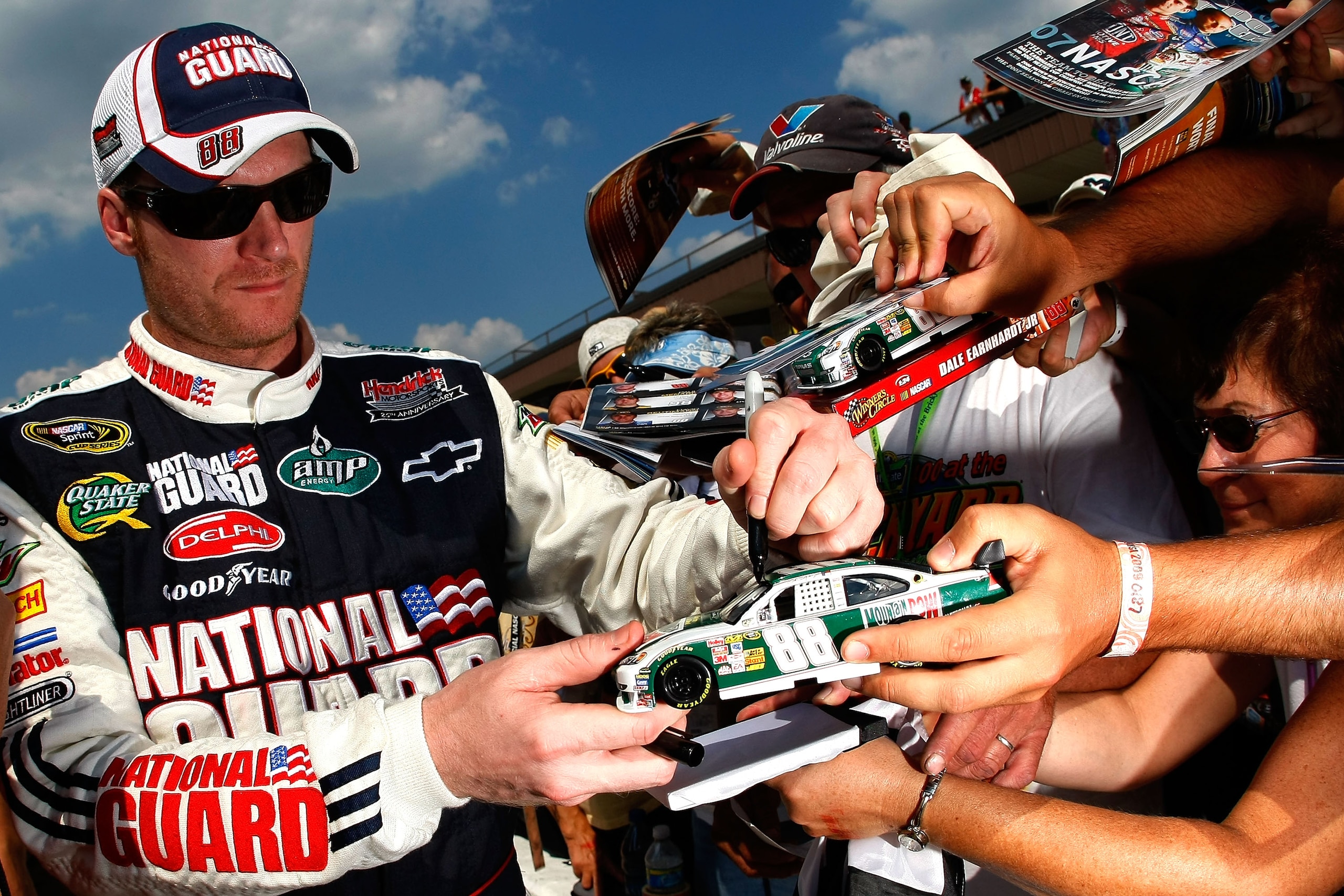 BROOKLYN, MI - AUGUST 14:  Dale Earnhardt Jr., driver of the #88 AMP Energy/National Guard Chevrolet, signs autographs for fans after qualifying for the NASCAR Sprint Cup Series Michigan 400 at Michigan Internetional Speedway on August 14, 2009 in Brookly