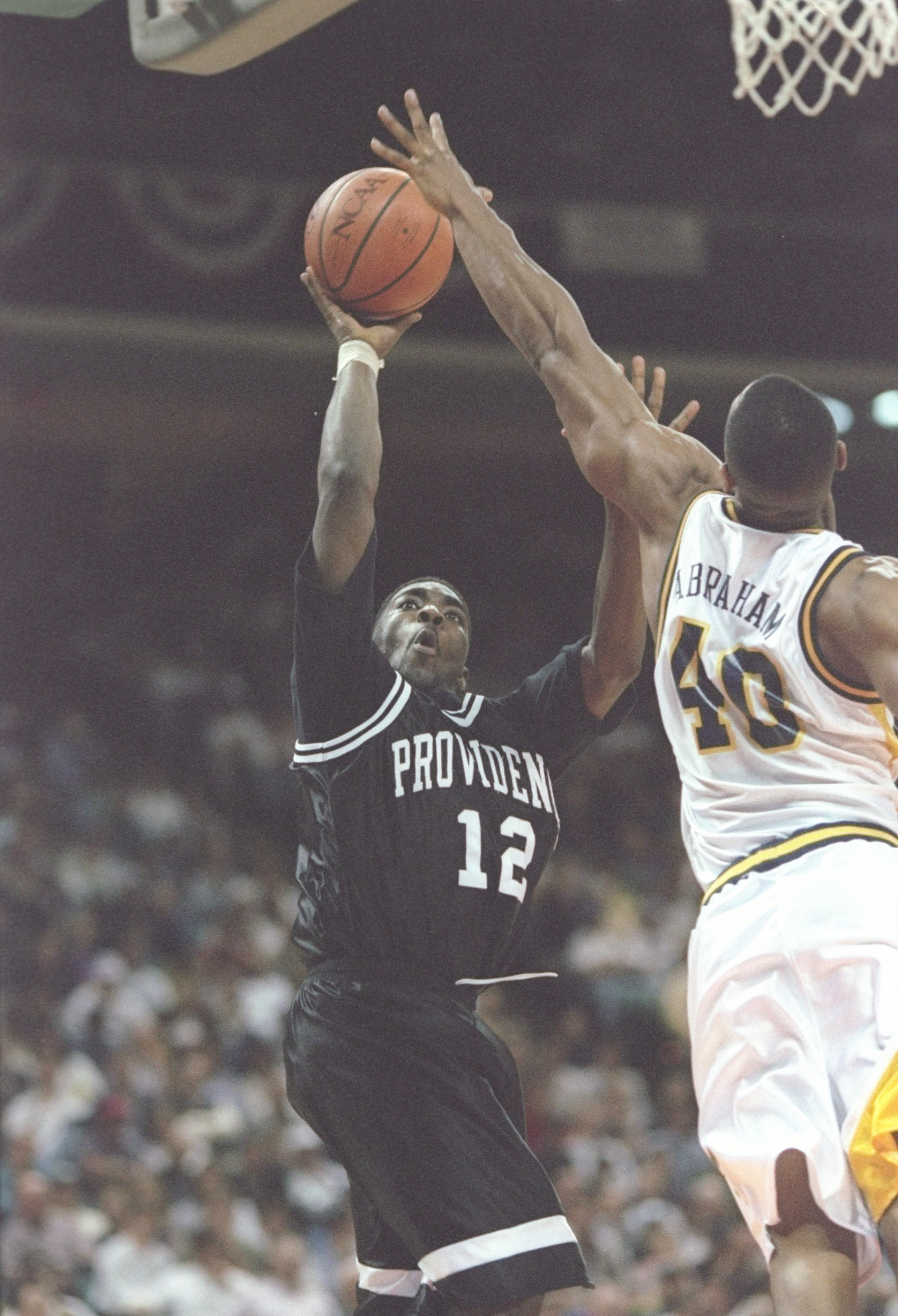 14 Mar 1997: Guard God Shammgod of the Providence Friars shoots a basket as forward Faisal Abraham of the Marquette Golden Eagles tries to block during a playoff game at the Charlotte Coliseum in Charlotte, North Carolina. The Friars won the game 81 - 59.