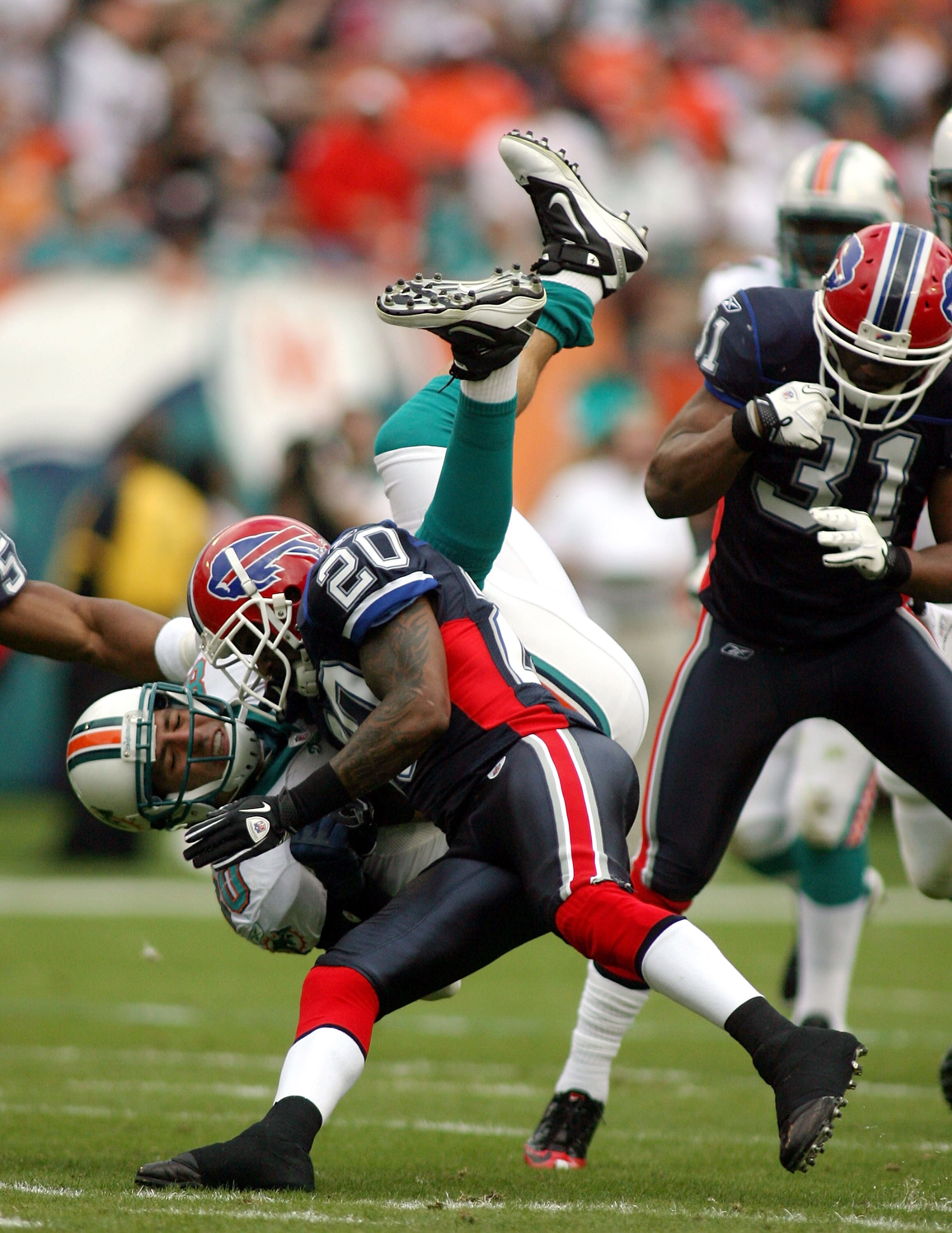 MIAMI, FL - DECEMBER 19: Tight end Anthony Fasano #80 of the Miami Dolphins is upended by cornerback Donte Whitner #20 of the Buffalo Bills during a game at Sun Life Stadium on December 19, 2010 in Miami, Florida.  (Photo by Marc Serota/Getty Images)