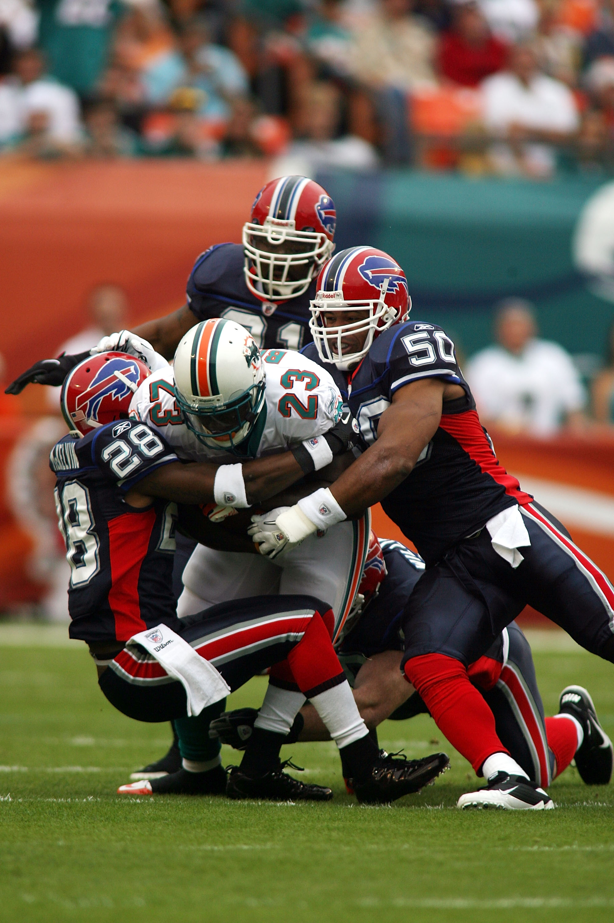 MIAMI, FL - DECEMBER 19:  Running back Ronnie Brown #23 of the Miami Dolphins is upended by cornerback Leodis McKelvin #28 and Akin Ayodele #50 of the Buffalo Bills at Sun Life Stadium on December 19, 2010 in Miami, Florida.  (Photo by Marc Serota/Getty I