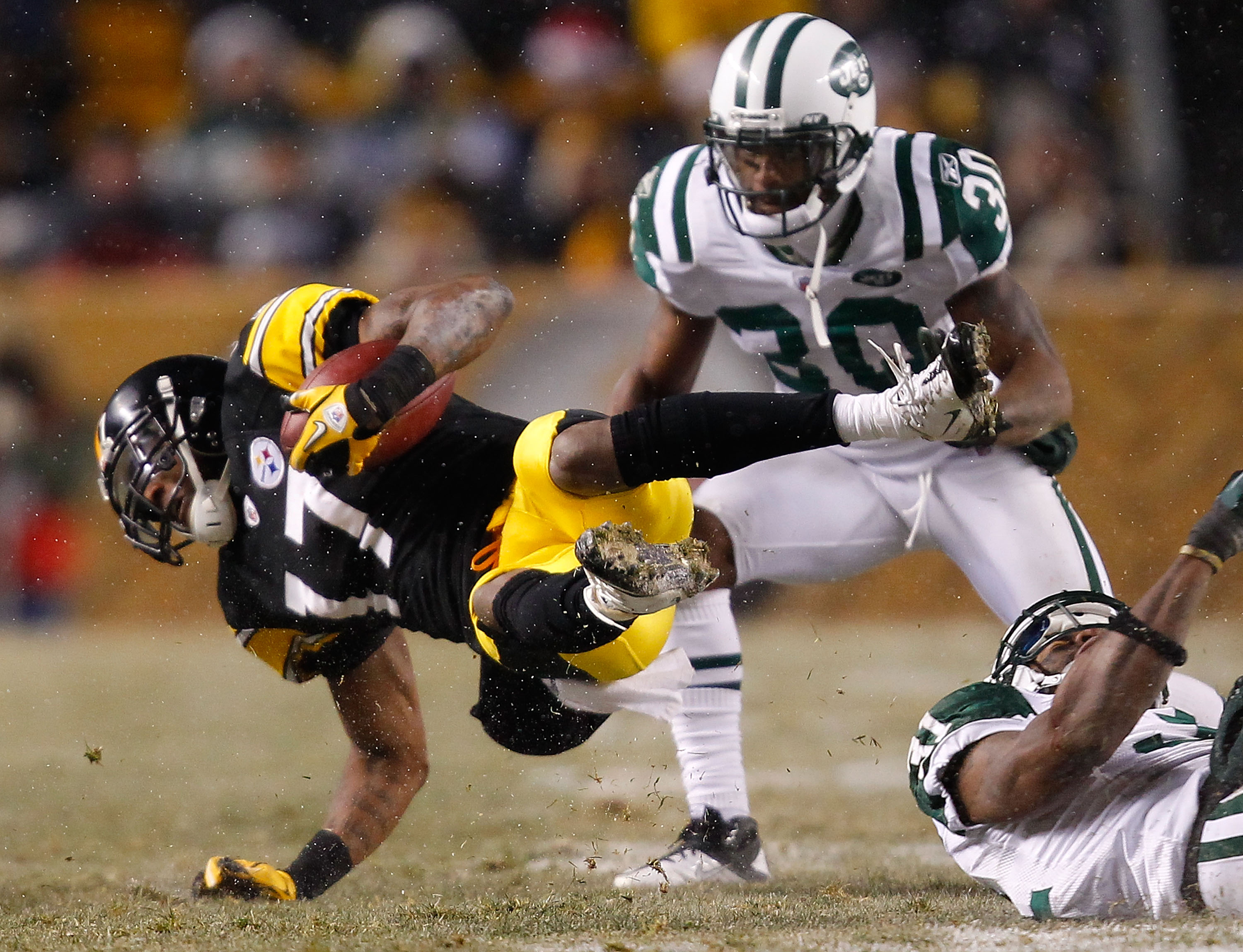 PITTSBURGH - DECEMBER 19:  Mike Wallace #17 of the Pittsburgh Steelers is tripped up by members of the New York Jets defense after catching a pass during the game on December 19, 2010 at Heinz Field in Pittsburgh, Pennsylvania.  (Photo by Jared Wickerham/