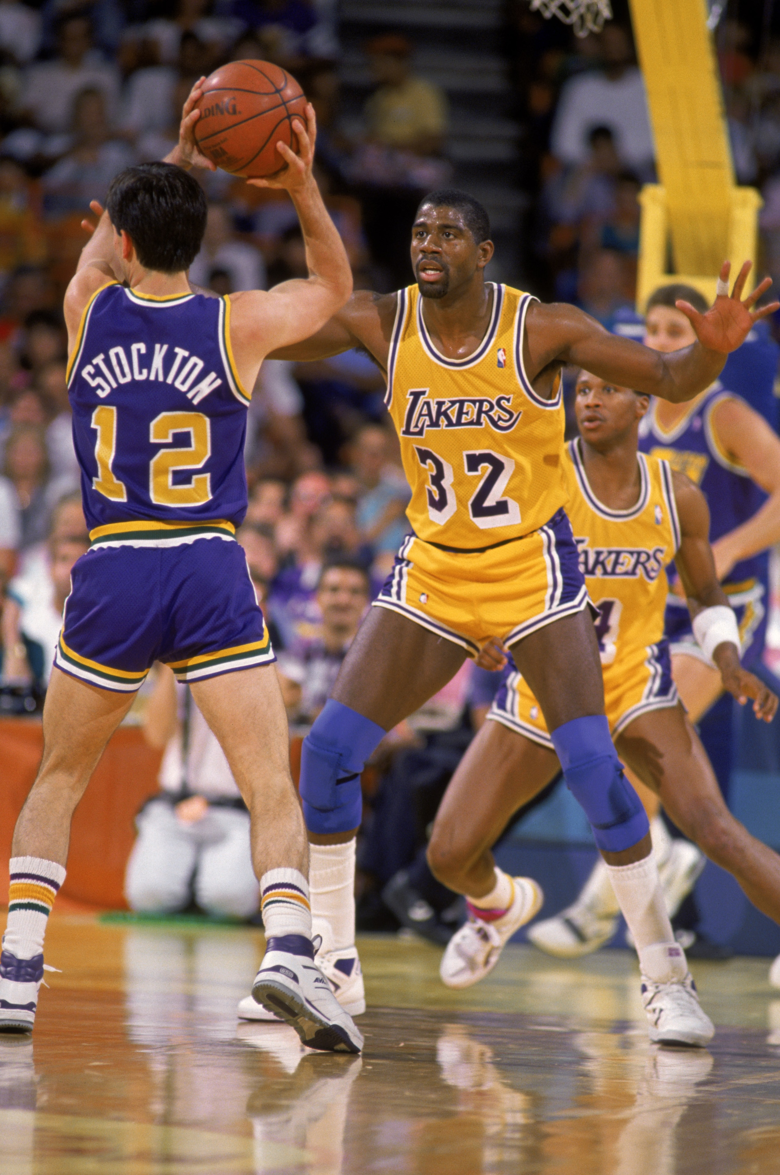 LOS ANGELES - 1987:  Magic Johnson #32 of the Los Angeles Lakers guards John Stockton #12 of the Utah Jazz during an NBA game at the Great Western Forum in Los Angeles, California in 1987. (Photo by: Stephen Dunn/Getty Images)