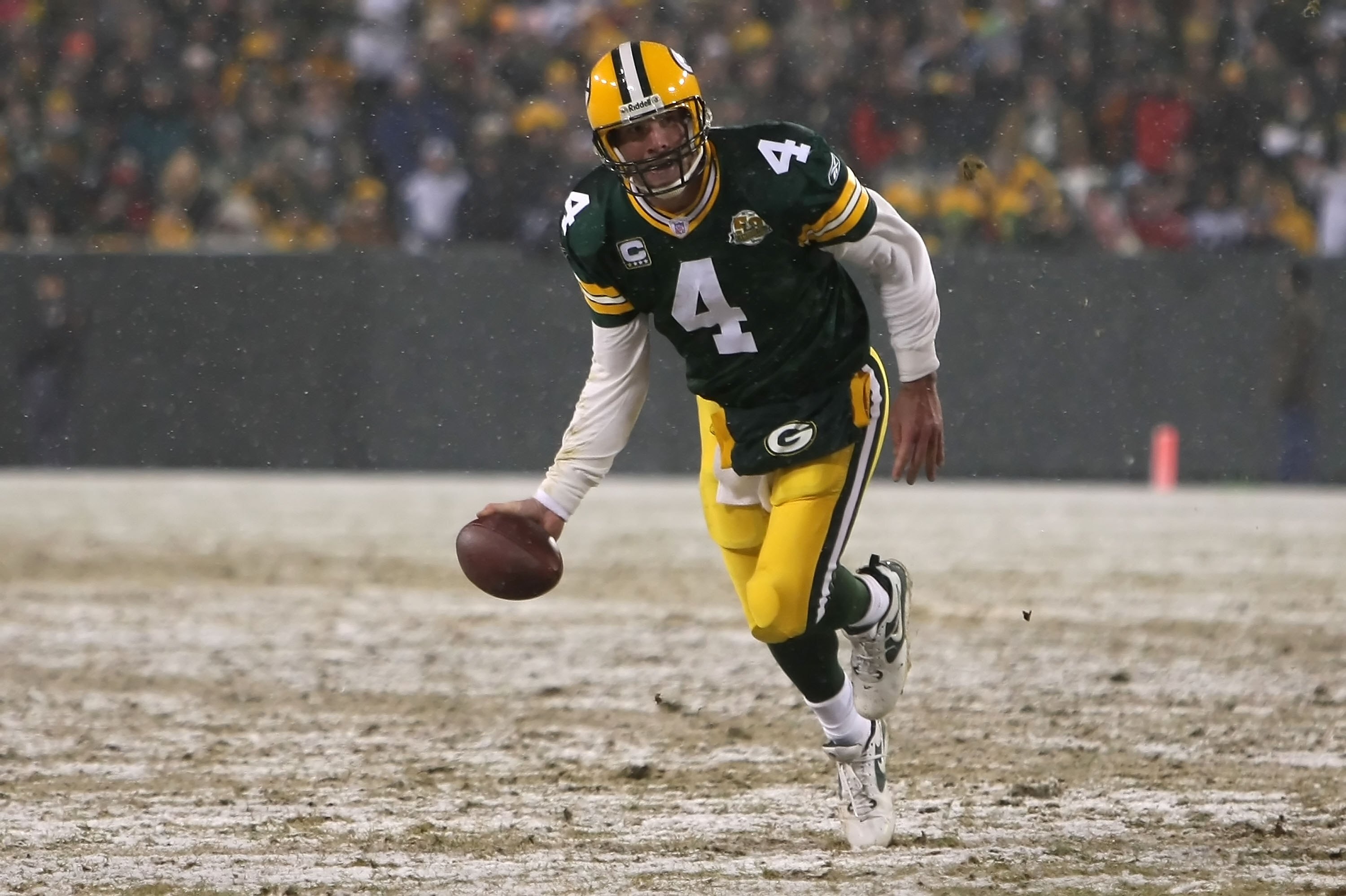 GREEN BAY, WI - JANUARY 12:  Quarterback Brett Favre #4 of the Green Bay Packers tries to keep his balance before he throws a shovel pass to tight end Donald Lee #86 for an 11-yard gain in the second quarter against the Seattle Seahawks during the NFC div