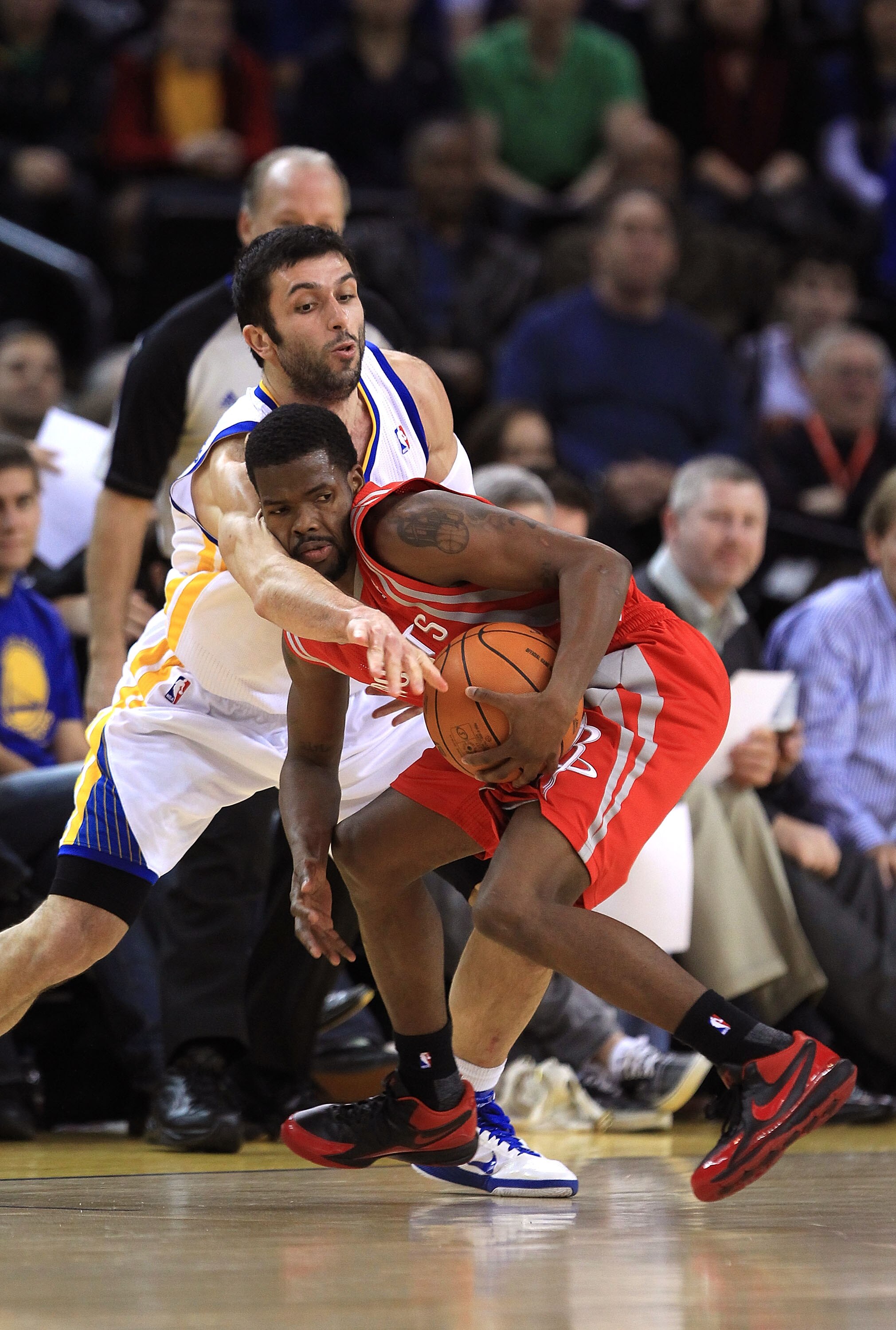 OAKLAND, CA - DECEMBER 20:  Vladimir Radmanovic #77 of the Golden State Warriors fouls Aaron Brooks #0 the Houston Rockets at Oracle Arena on December 20, 2010 in Oakland, California. NOTE TO USER: User expressly acknowledges and agrees that, by downloadi