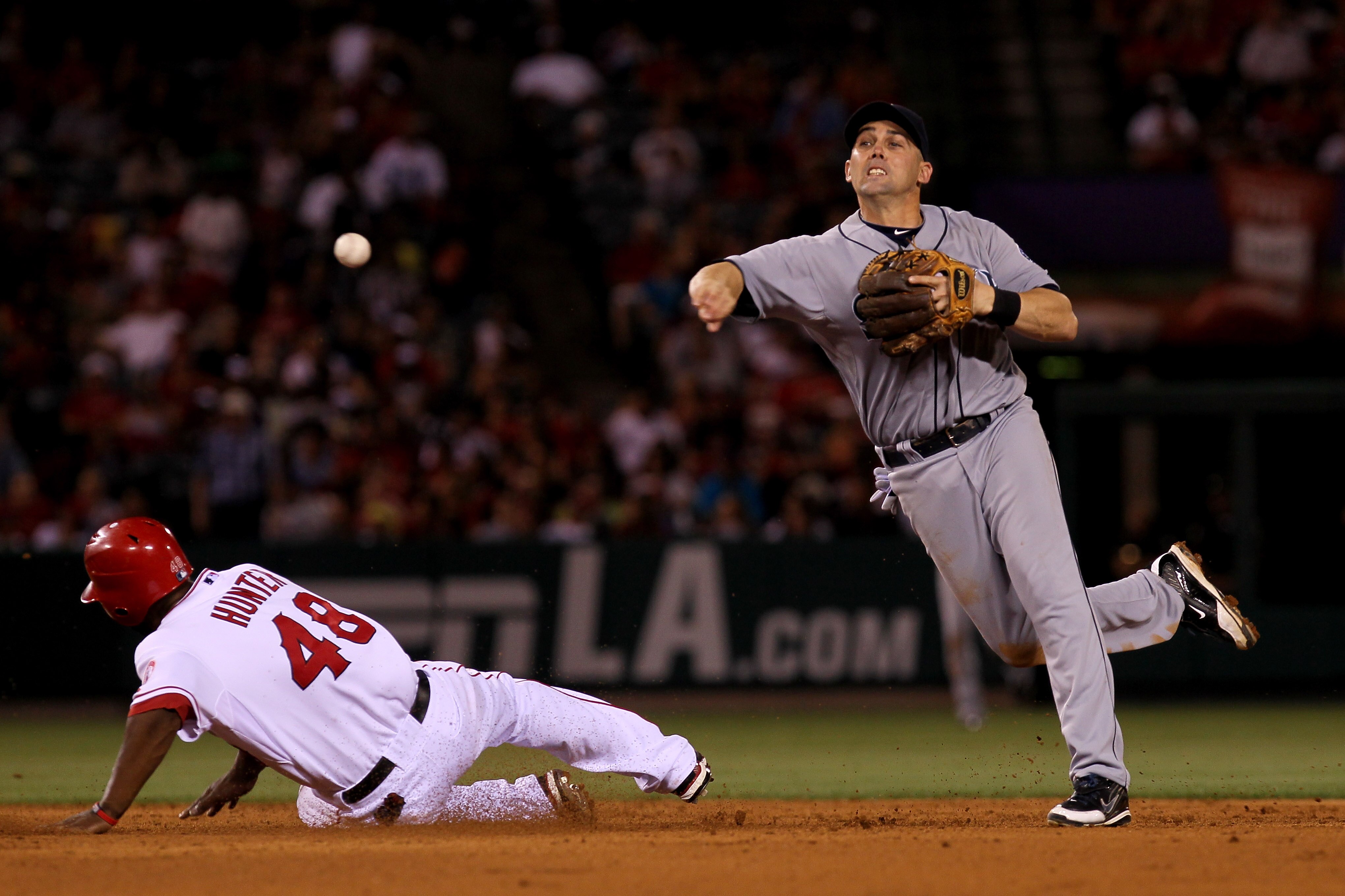 ANAHEIM, CA - JULY 16: Shortstop Jack Wilson  #32 of the Seattle Mariners throws to first to complete a double play after forcing out Torii Hunter #48 of the Los Angeles Angels of Anaheim in the sixth inning on July 16, 2010 at Angel Stadium in Anaheim, C