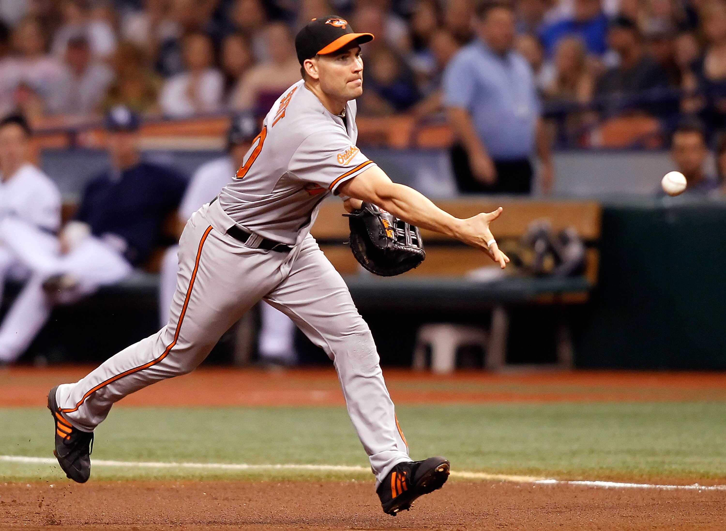 ST. PETERSBURG, FL - SEPTEMBER 29:  Infielder Luke Scott #30 of the Baltimore Orioles tosses the ball over to the pitcher for an out at first against the Tampa Bay Rays during the game at Tropicana Field on September 29, 2010 in St. Petersburg, Florida.