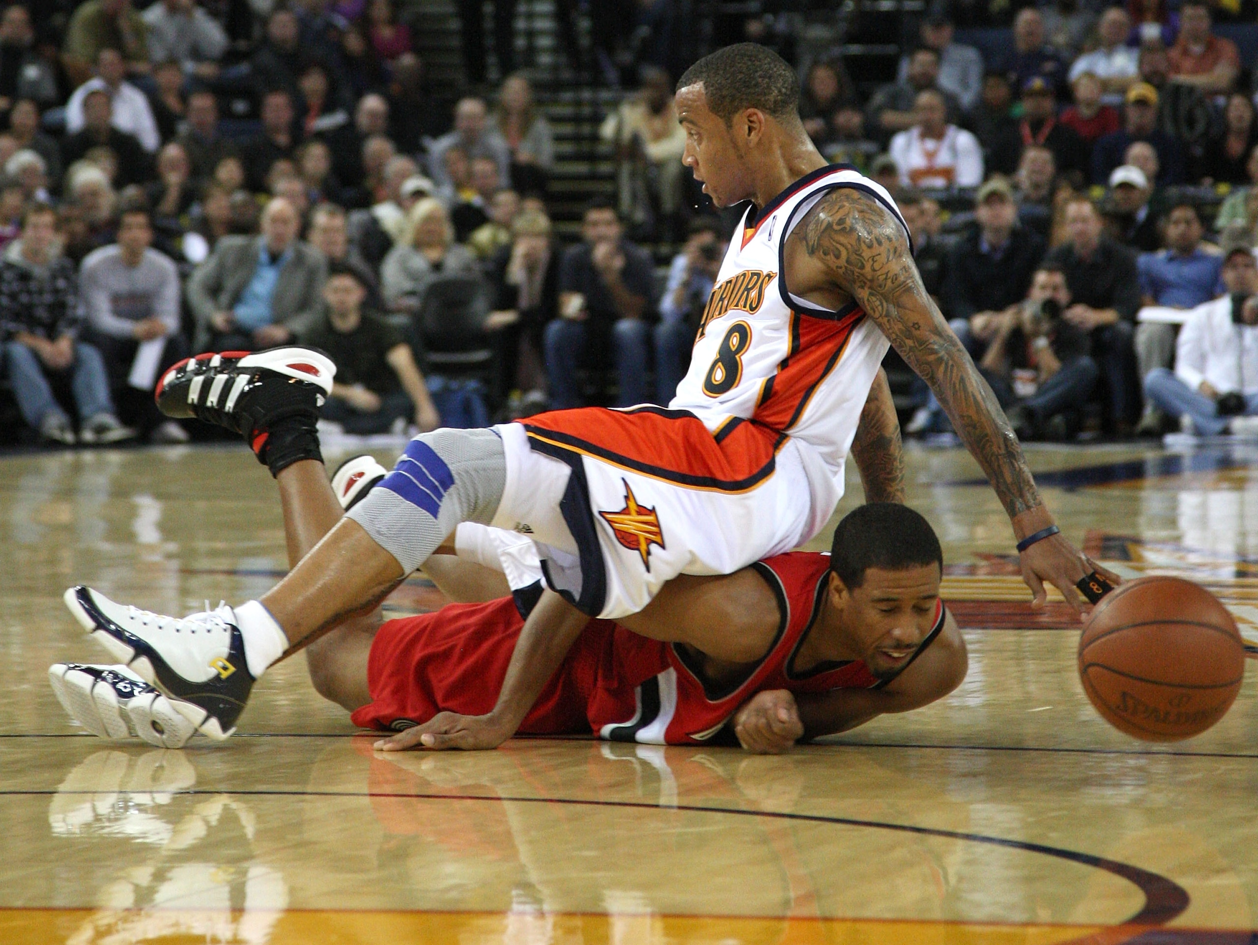 OAKLAND, CA - NOVEMBER 20:  Monta Ellis #8 of the Golden State Warriors scrambles for the ball with Andre Miller #24 of the Portland Trail Blazers during an NBA game at Oracle Arena on November 20, 2009 in Oakland, California. (Photo by Jed Jacobsohn/Gett