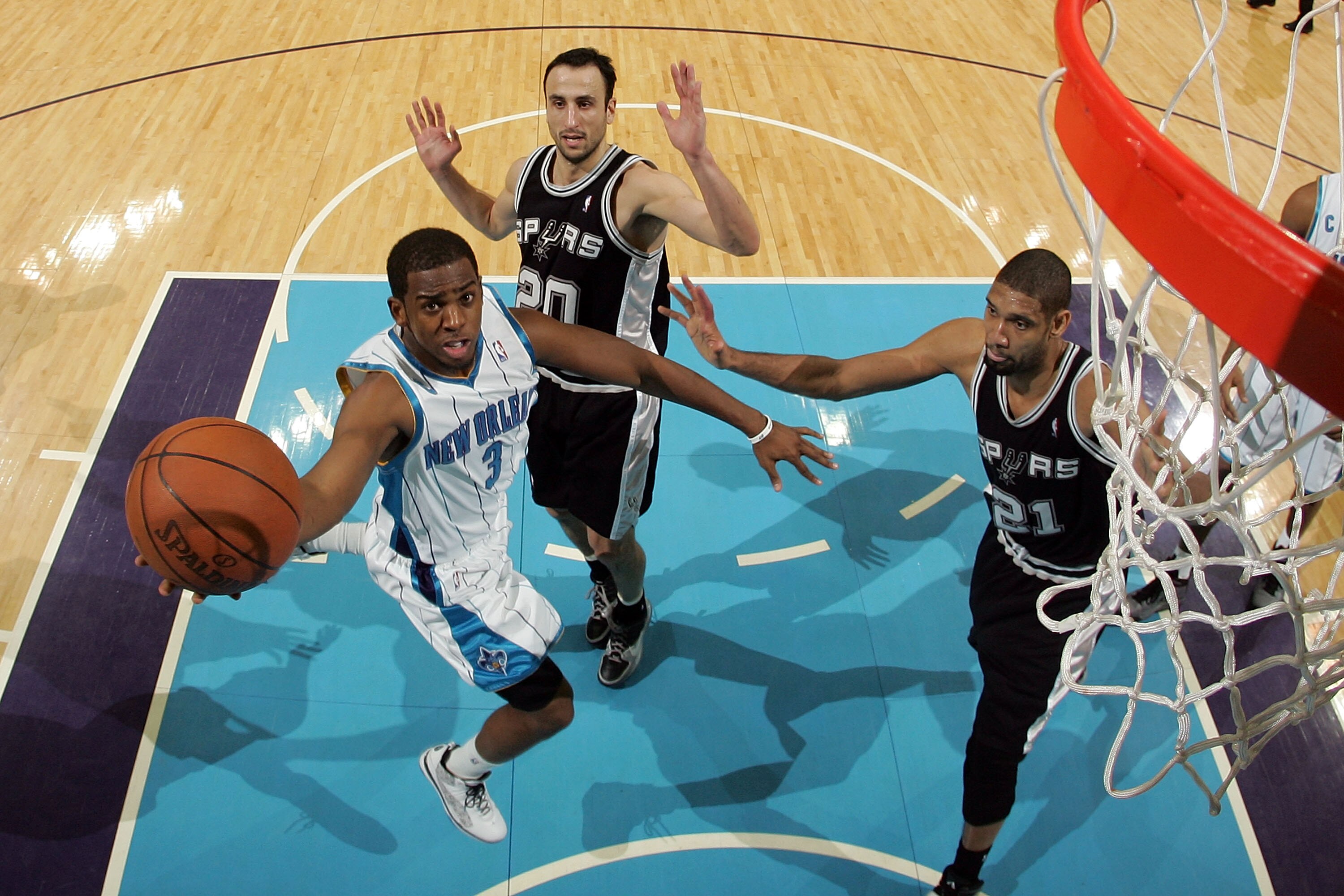 NEW ORLEANS - JANUARY 18:  Chris Paul #3 of the New Orleans Hornets shoots the ball over Manu Ginobili #20 and Tim Duncan #21 of the San Antonio Spurs at New Orleans Arena on January 18, 2010 in New Orleans, Louisiana. The Spurs defeated the Hornets 97-90