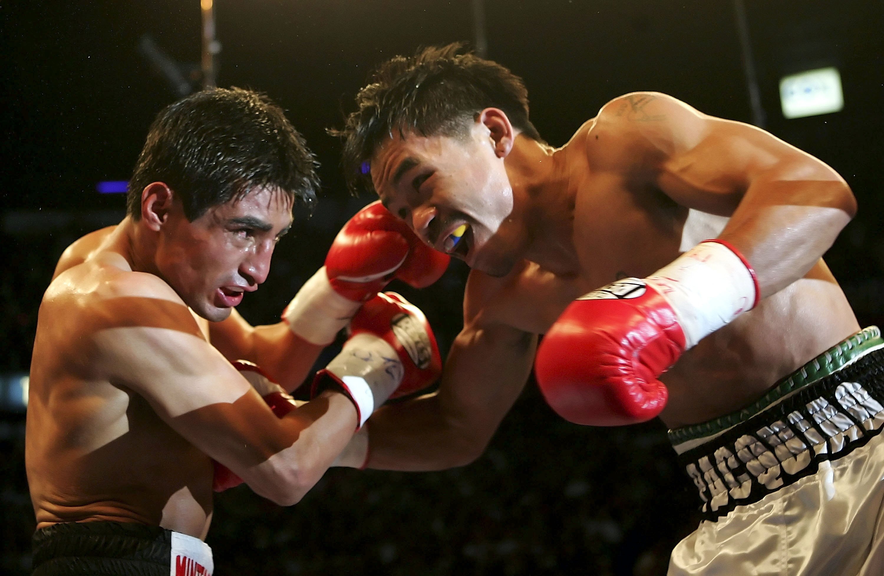 LAS VEGAS - NOVEMBER 18:  (R-L) Manny Pacquiao of the Philippines and Erik Morales of Mexico exchange blows during their super featherweight bout at the Thomas & Mack Center on November 18, 2006 in Las Vegas, Nevada. Pacquiao won after a third round knock
