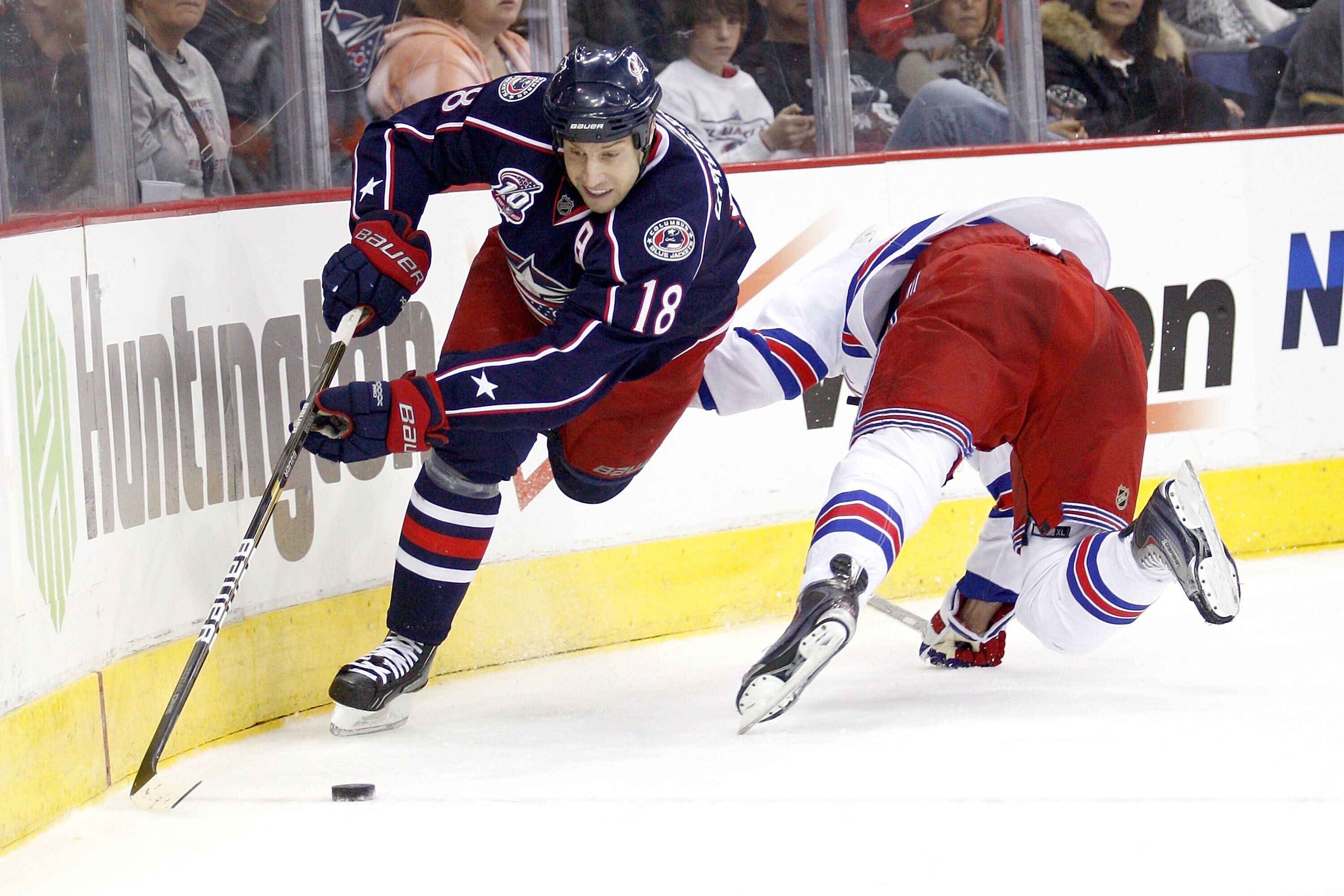 COLUMBUS,OH - DECEMBER 11:  R.J. Umberger #18 of the Columbus Blue Jackets slips past Marc Staal #18 of the New York Rangers to get to a loose puck during the second period on December 11, 2010 at Nationwide Arena in Columbus, Ohio.  (Photo by John Griesh
