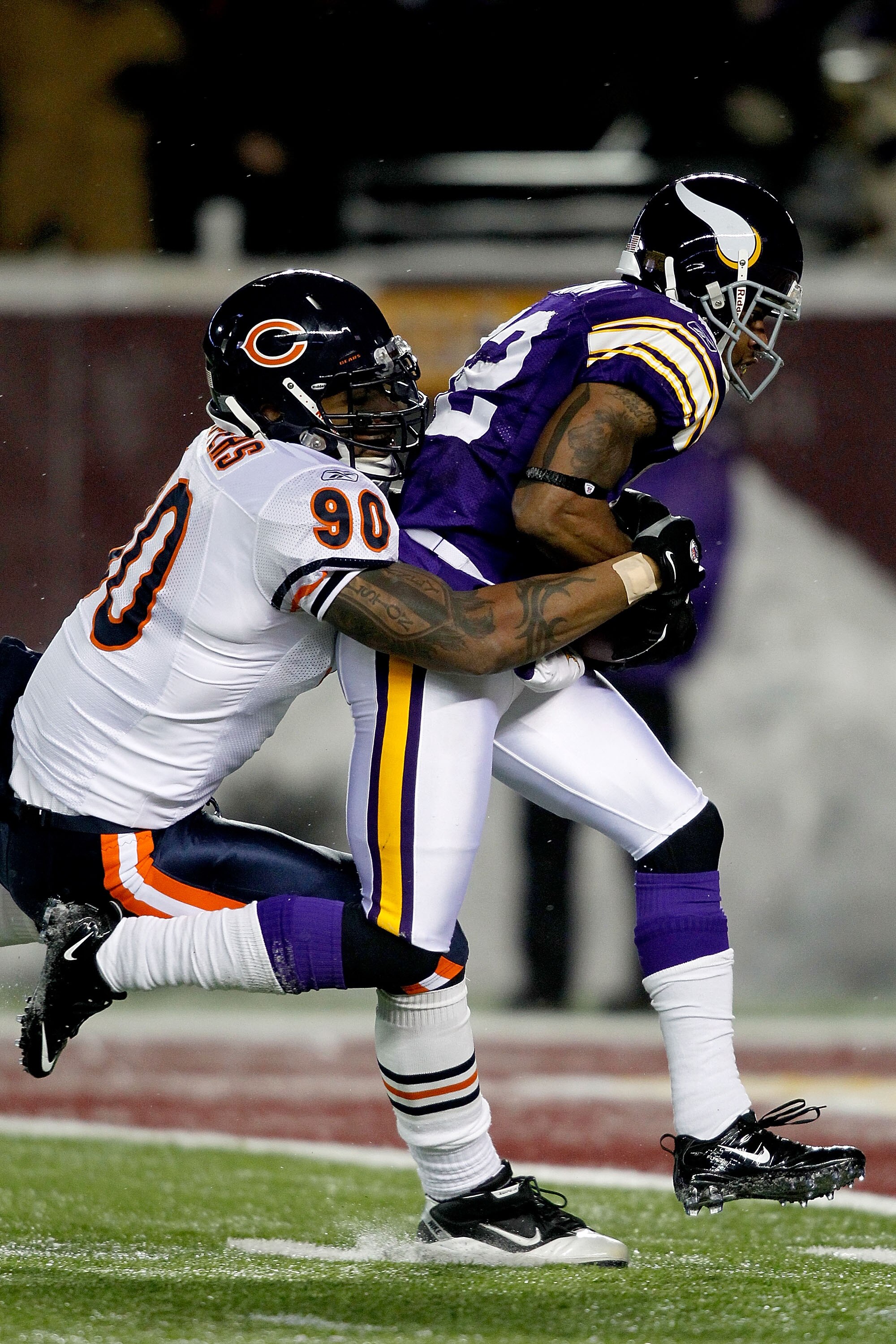 MINNEAPOLIS, MN - DECEMBER 20:  Percy Harvin #12 of the Minnesota Vikings of the Minnesota Vikings slips out of the grasp of Julius Peppers #90 of the Chicago Bears  for a touchdown at TCF Bank Stadium on December 20, 2010 in Minneapolis, Minnesota.  (Pho