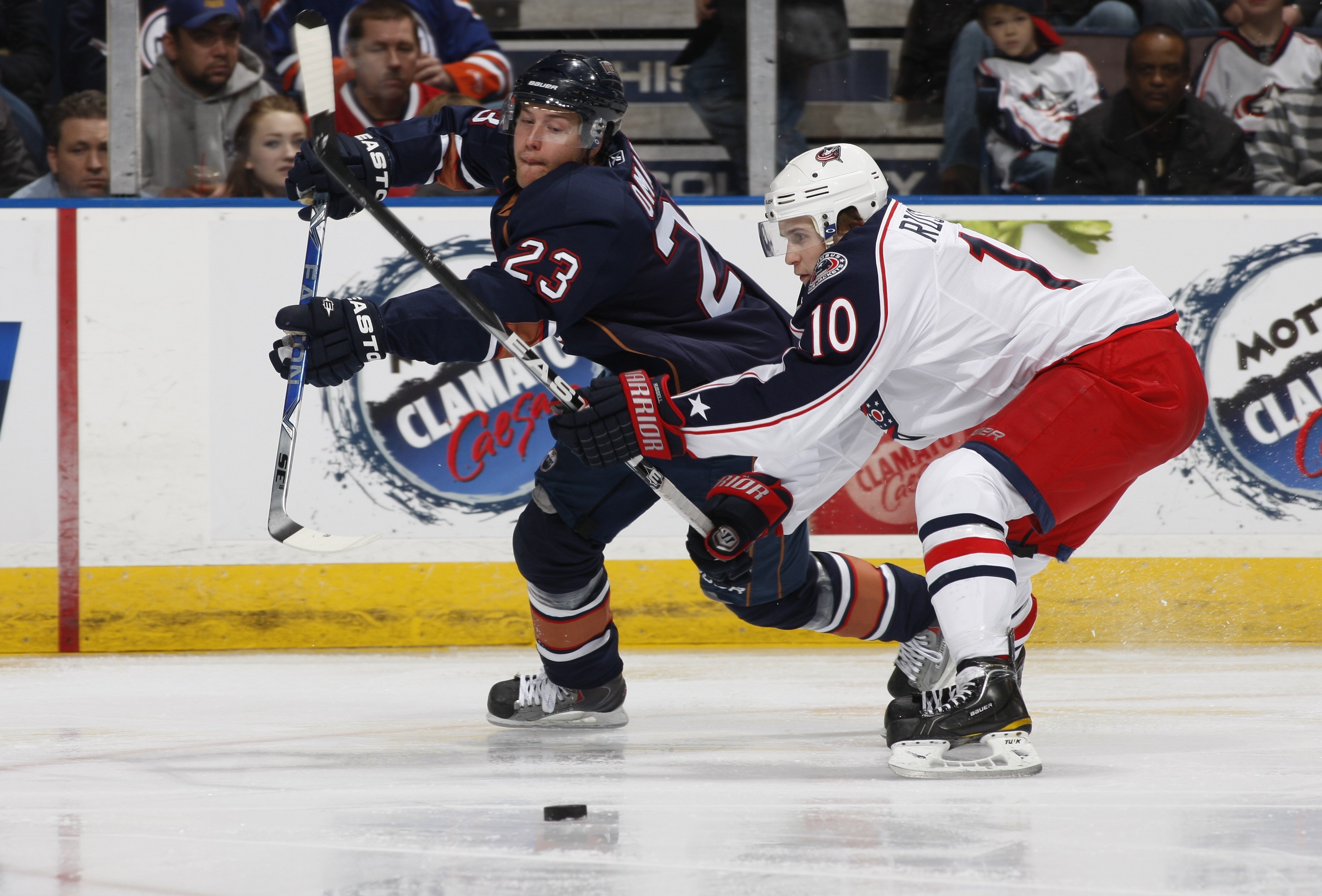 EDMONTON, CANADA - DECEMBER 16: Linus Omark #23 of the Edmonton Oilers is checked by Kris Russell #10 of the Columbus Blue Jackets at Rexall Place December 16, 2010 in Edmonton, Alberta, Canada. (Photo by Dale MacMillan/Getty Images)