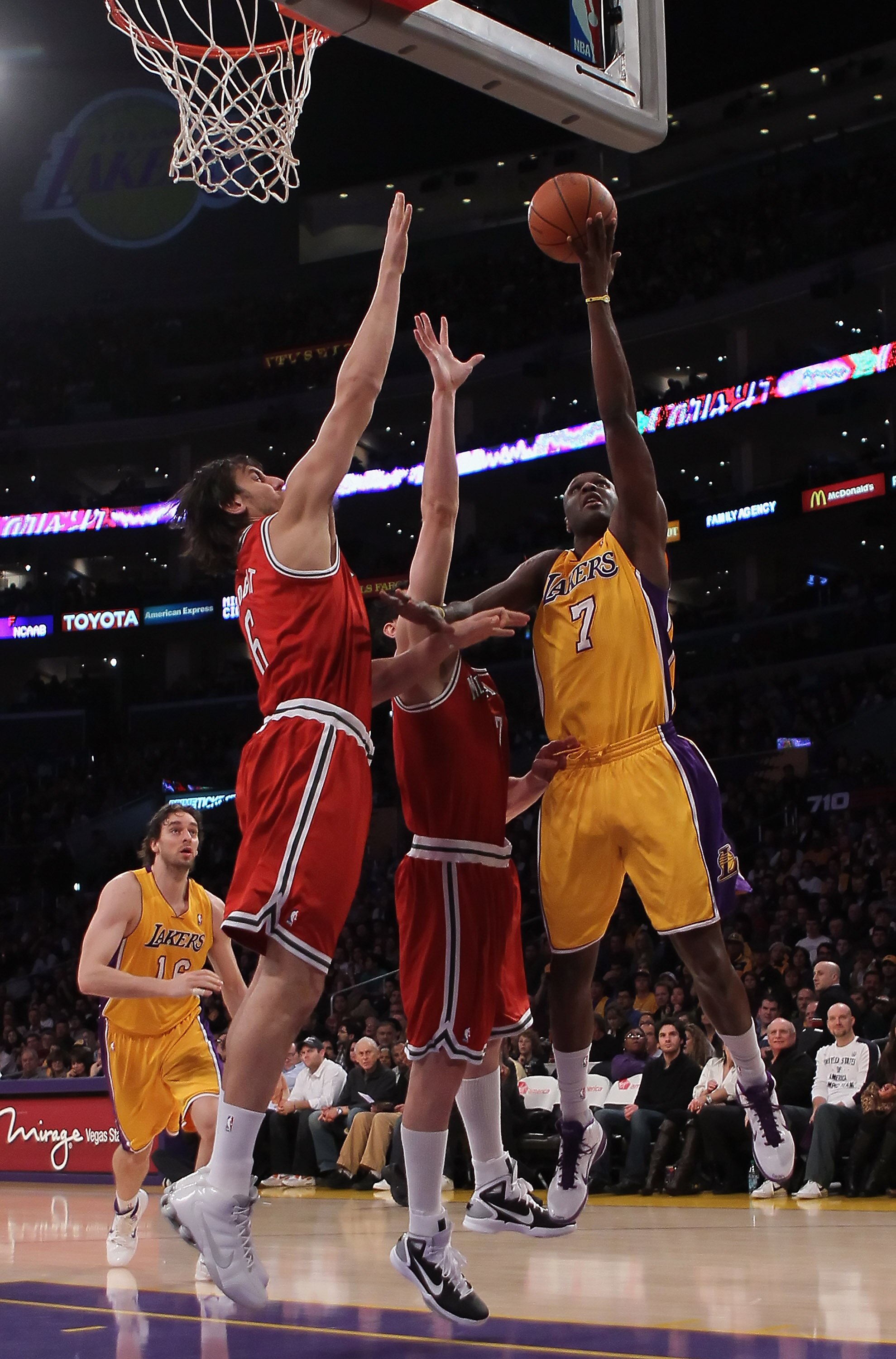 LOS ANGELES, CA - DECEMBER 21:  Lamar Odom #7 of the Los Angeles Lakers drives to the basket while being defended by Andrew Bogut (L) #6 and Ersan Ilyasova #7 of the Milwaukee Bucks during the first half at Staples Center on December 21, 2010 in Los Angel