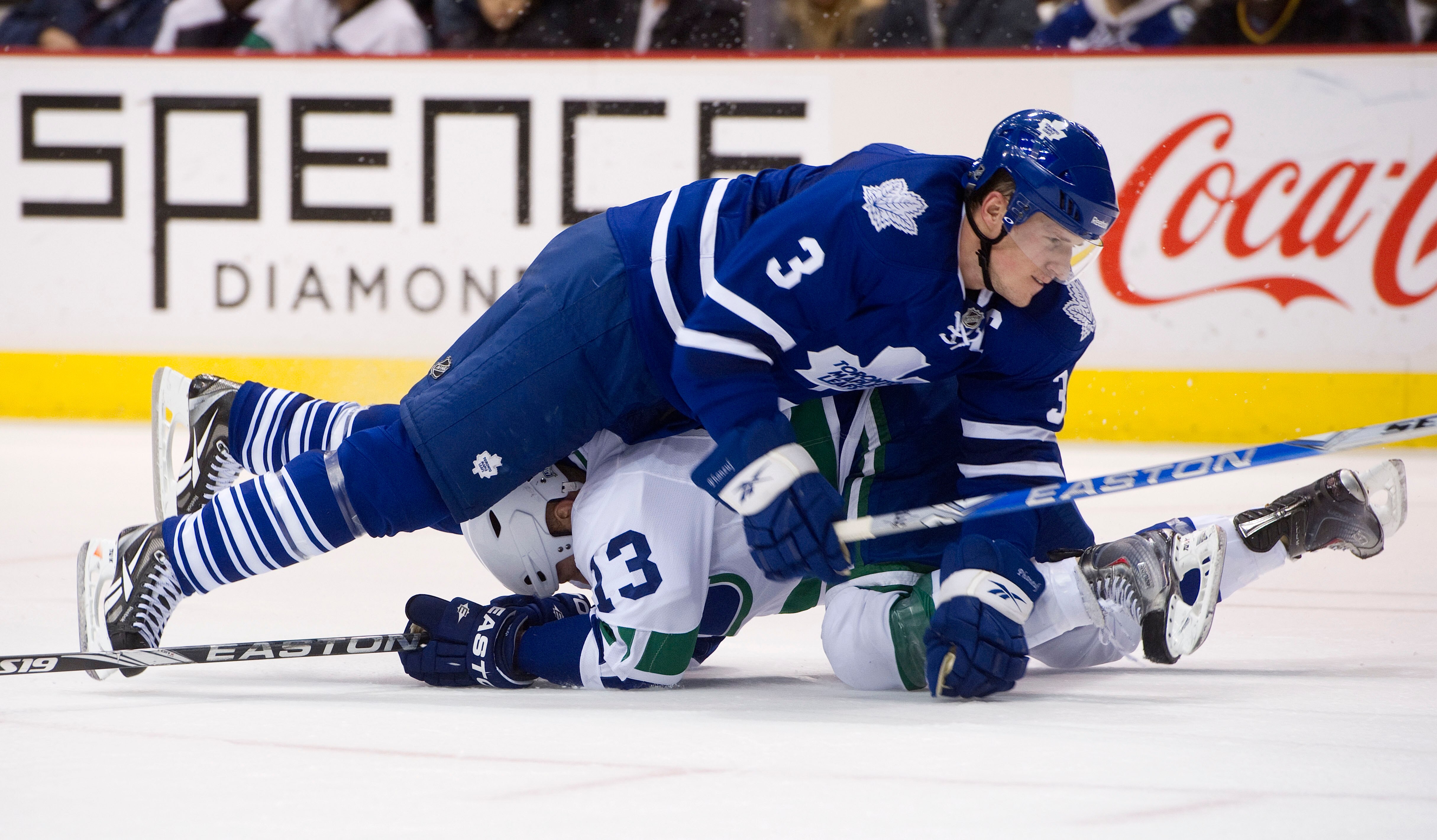 VANCOUVER, CANADA - DECEMBER 18: Dion Phaneuf #3 of the Toronto Maple Leafs falls on top of Raffi Torres #13 during the second period in NHL action on December 18, 2010 at Rogers Arena in Vancouver, BC, Canada.  (Photo by Rich Lam/Getty Images)