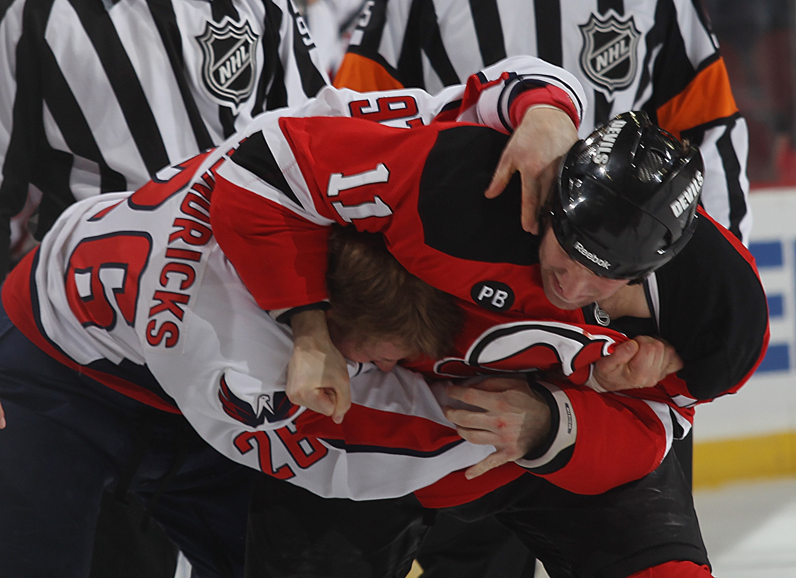 NEWARK, NJ - NOVEMBER 22: Adam Mair #11 of the New Jersey Devils and Matt Henricks #26 of the Washington Capitals fight during the first period at the Prudential Center on November 22, 2010 in Newark, New Jersey.  (Photo by Bruce Bennett/Getty Images)