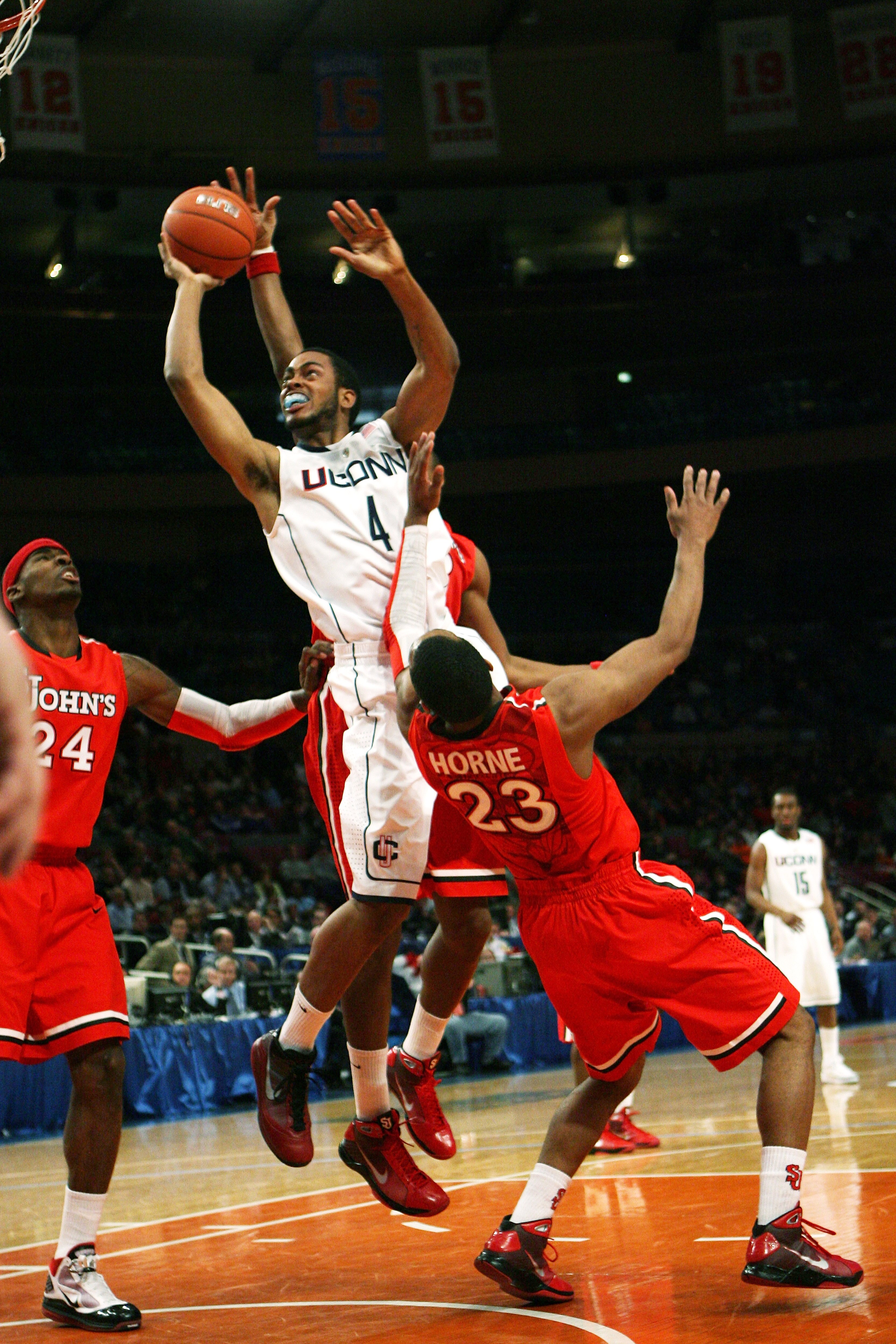 NEW YORK - MARCH 09: Jamal Coombs-McDaniel #4 the Connecticut Huskies drives to the basket over  Paris Horne #23 of the St. John's Red Storm at Madison Square Garden on March 9, 2010 in New York, New York. The Red Storm defeated the Huskies 73-51.  (Photo