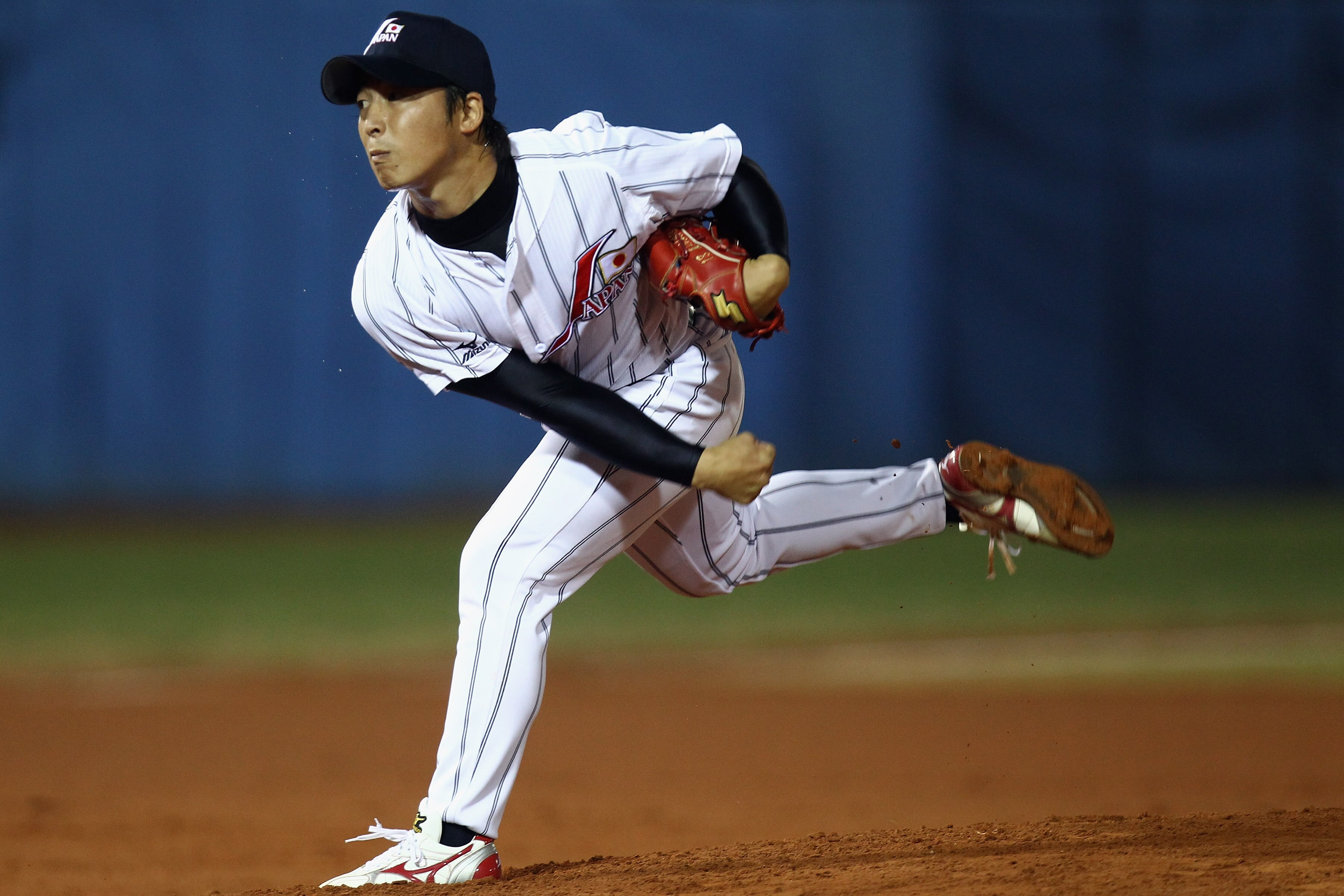GUANGZHOU, CHINA - NOVEMBER 15: Manabu Mima of Japan pitches during the Men's Preliminary match between Japan and China at Aoti Baseball Field 1 during day three of the 16th Asian Games Guangzhou 2010 on November 15, 2010 in Guangzhou, China.  (Photo by H