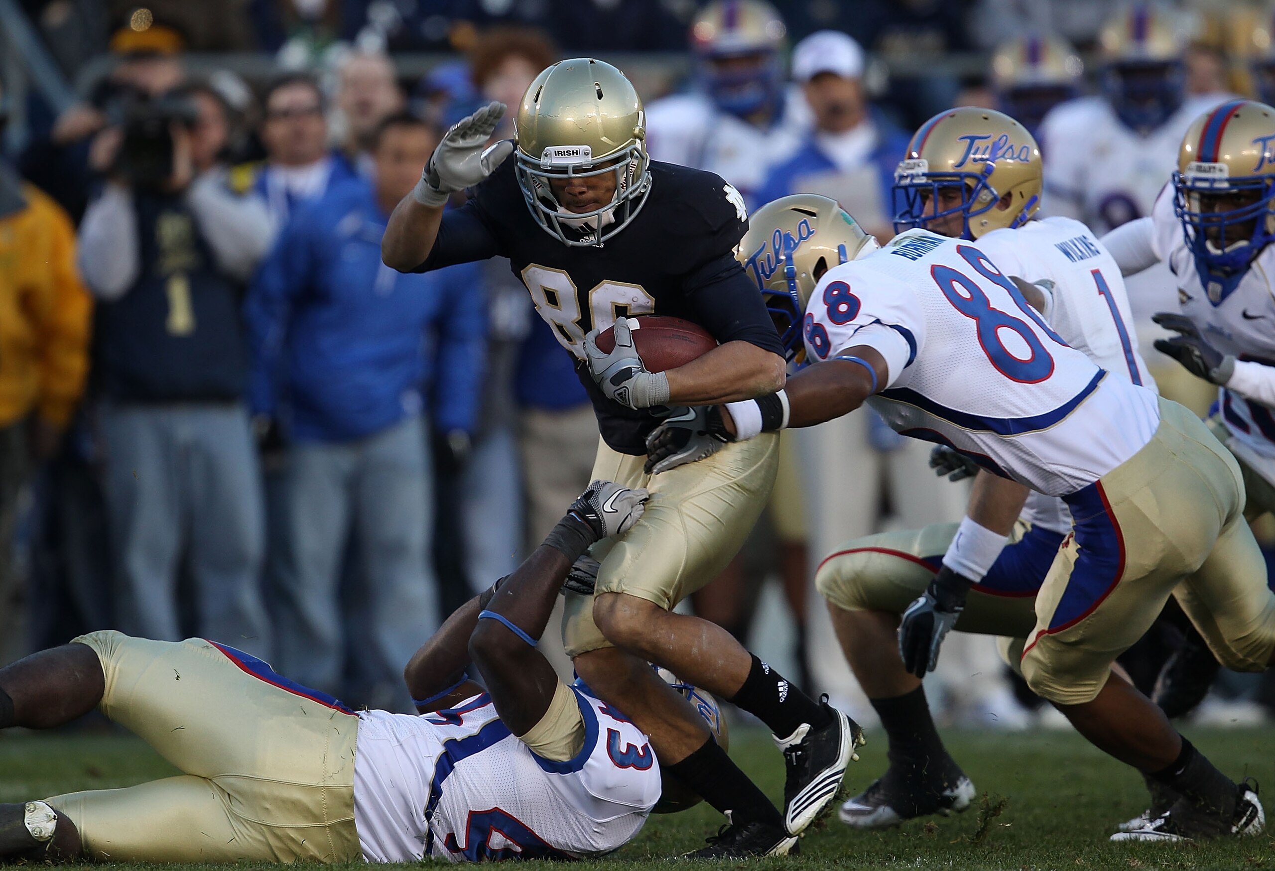 SOUTH BEND, IN - OCTOBER 30: Bennett Jackson #86 of the Notre Dame Fighting Irish is tackled by Donnell Hawkins #43 and Bryan Burnham #88 of the Tulsa Golden Hurricane at Notre Dame Stadium on October 30, 2010 in South Bend, Indiana. Tulsa defeated Notre