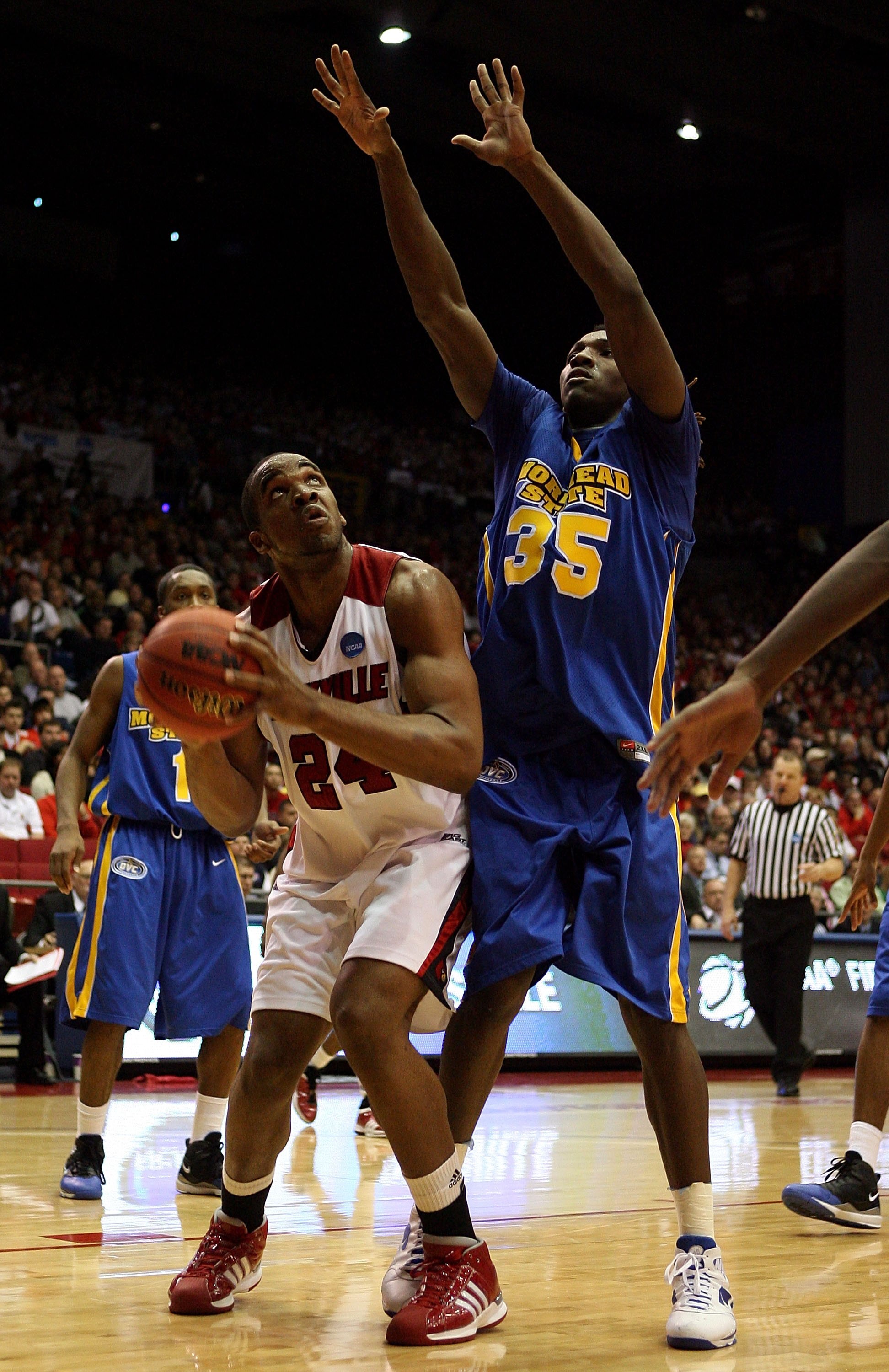 DAYTON, OH - MARCH 20: Samardo Samuels #24 of the Louisville Cardinals drives to the hoop against Kenneth Faried #35 of the Morehead State Eagles during the first round of the NCAA Division I Men's Basketball Tournament at the University of Dayton Arena o