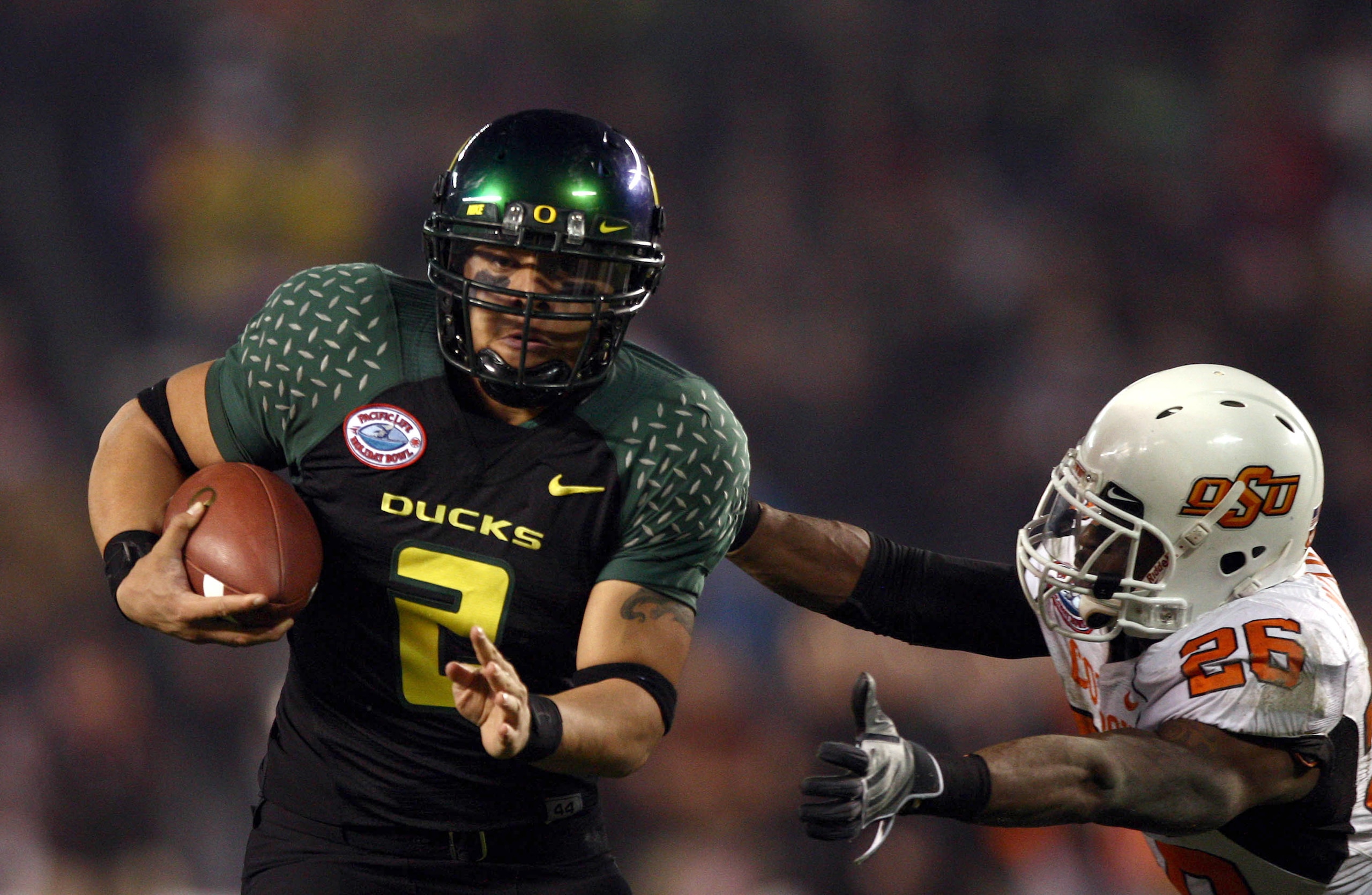 SAN DIEGO, CA - DECEMBER 30:   Quarterback Jeremiah Masoli #2 of the University of Oregon Ducks runs into the endzone for a touchdown against the tackle of Free Safety Quinton Moore #26 of the Oklahoma State University Cowboys during the Pacific Life Holi
