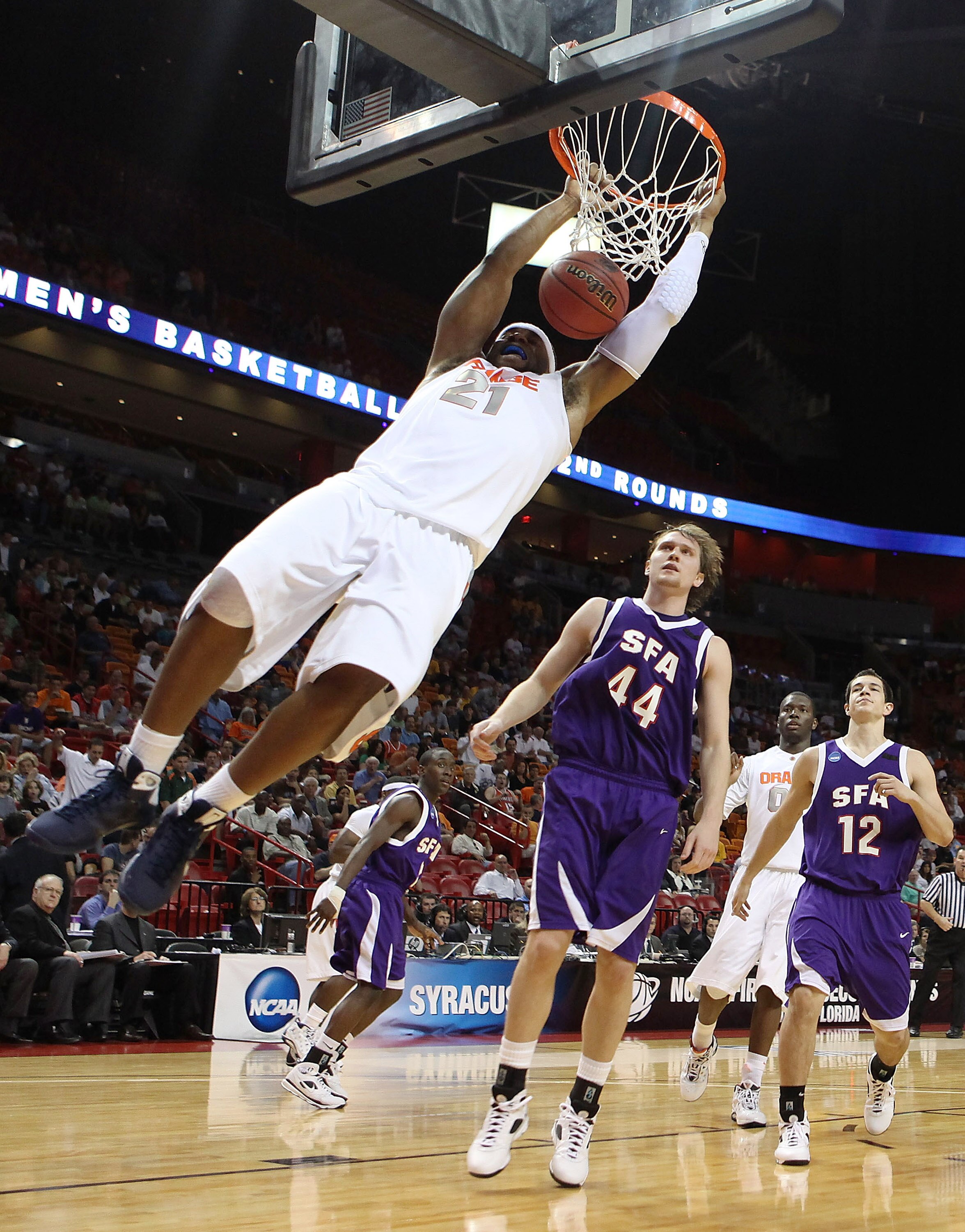 MIAMI - MARCH 20:  Guard Arinze Onuaku #21  of the Syracuse Orange dunks past center Matt Kingsley #44 and forward Nick Shaw #12 of the Stephen F. Austin Lumberjacks during the first round of the NCAA Division I Men's Basketball Tournament at the American