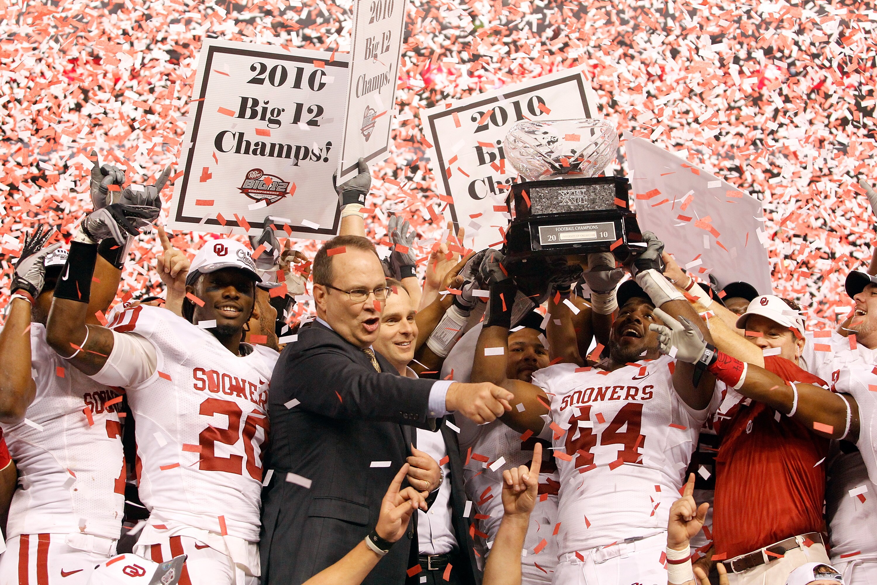 ARLINGTON, TX - DECEMBER 04:  Big 12 Commissioner Dan Bebee presents defensive end Jeremy Beal #44 of the Oklahoma Sooners with the Big 12 Championship Trophy after the Sooners beat the Nebraska Cornhuskers 23-20 at Cowboys Stadium on December 4, 2010 in