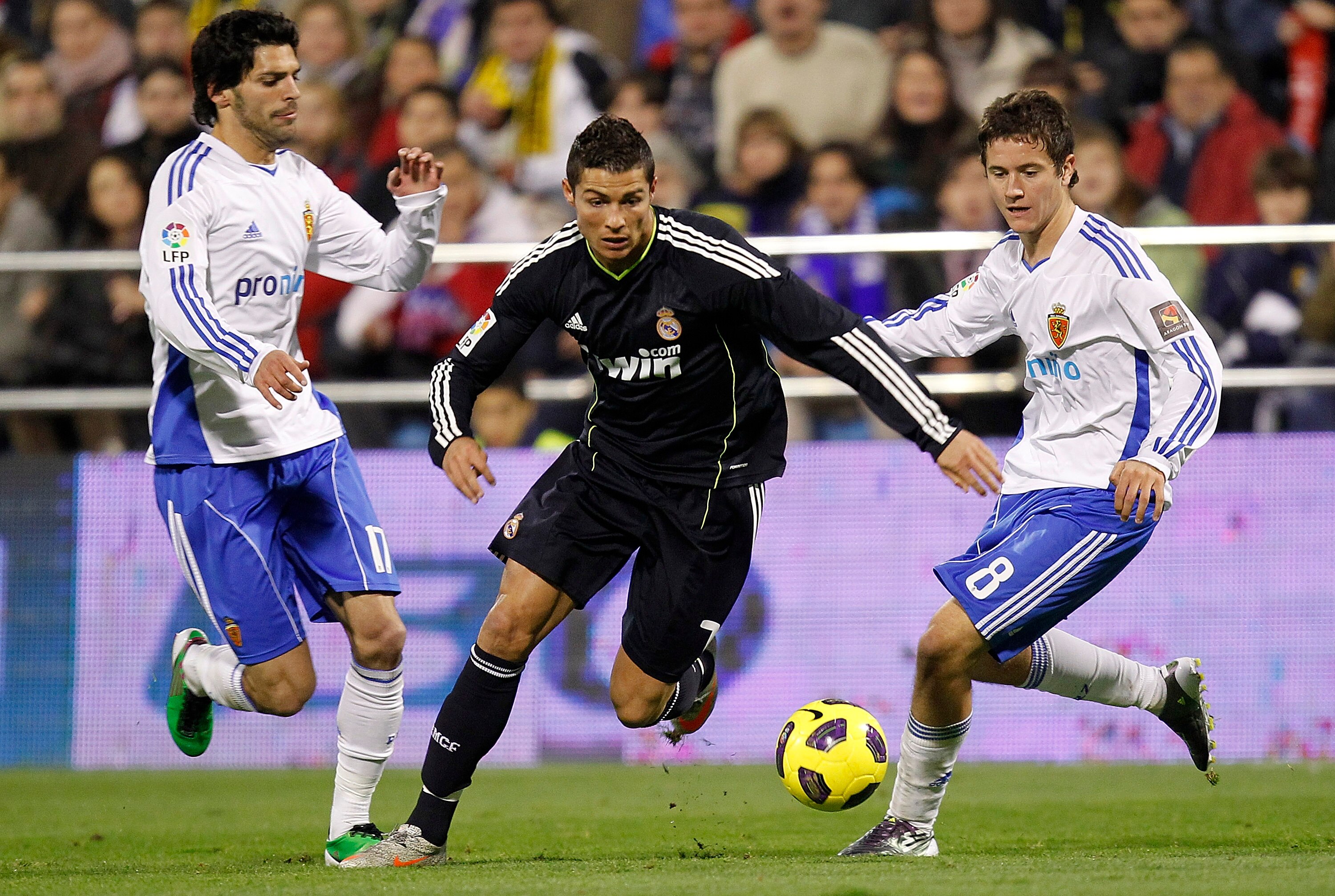 ZARAGOZA, SPAIN - DECEMBER 12: Cristiano Ronaldo of Real Madrid beats Ander Herrera and Angel Lafita of Zaragoza during the La Liga match between Real Zaragoza and Real Madrid at La Romareda stadium on December 12, 2010 in Zaragoza, Spain. (Photo by Angel