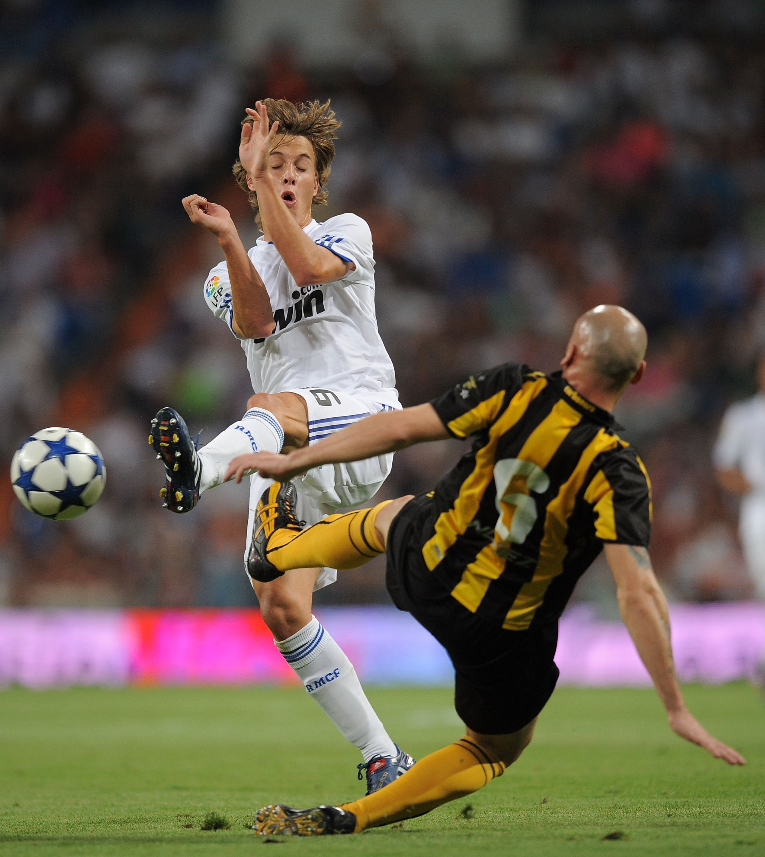 MADRID, SPAIN - AUGUST 24: Sergio Canales (L) of Real Madrid is tackled by Guillermo Rodriguez of Penarol during the Santiago Bernabeu Trophy match between Real Madrid and Penarol at the Santiago Bernabeu stadium on August 24, 2010 in Madrid, Spain.  (Pho