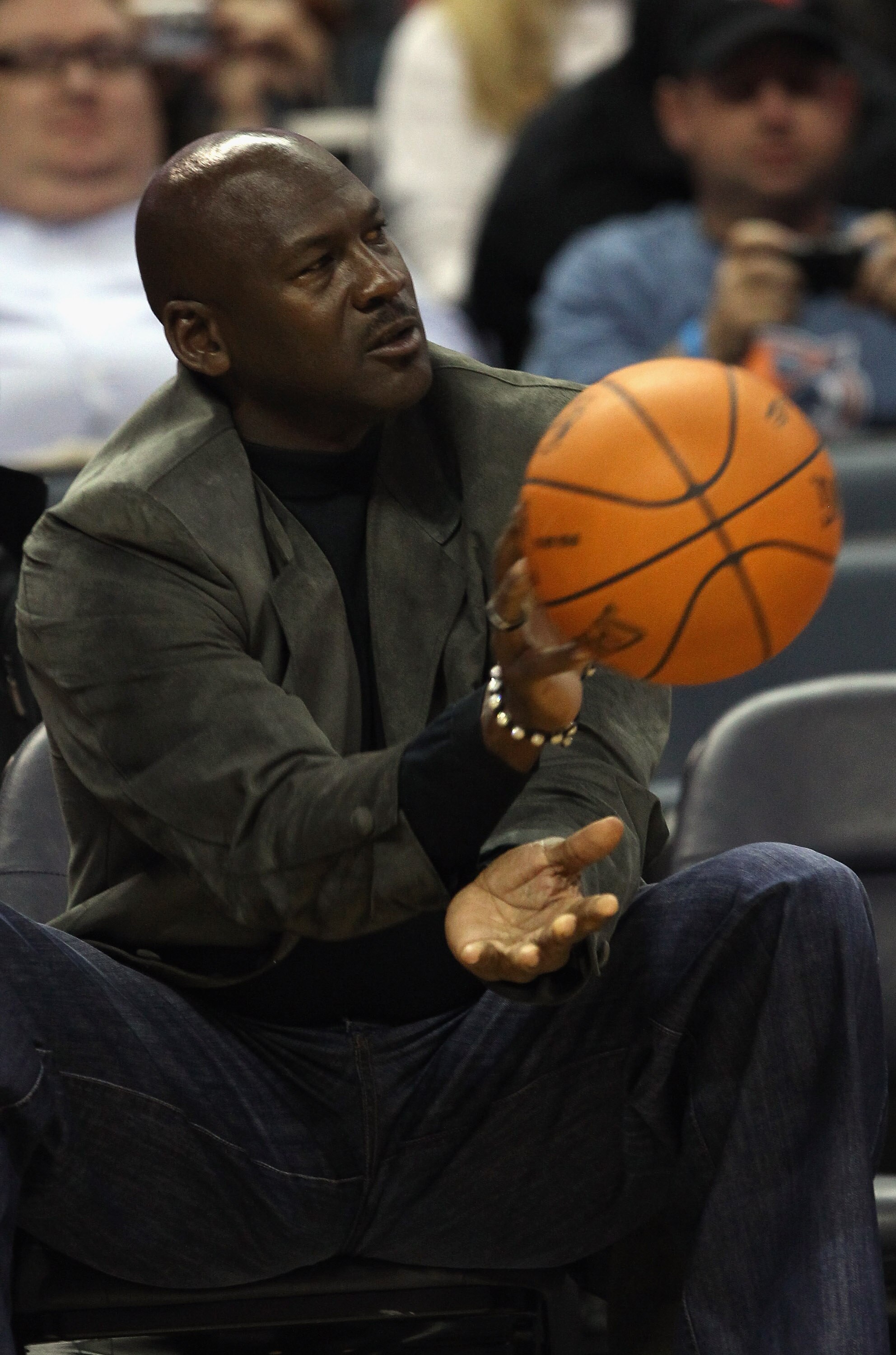 CHARLOTTE, NC - NOVEMBER 08:  Michael Jordan, owner of the Charlotte Bobcats, throws the ball back to an official during their game against the San Antonio Spurs at Time Warner Cable Arena on November 8, 2010 in Charlotte, North Carolina.  NOTE TO USER: U