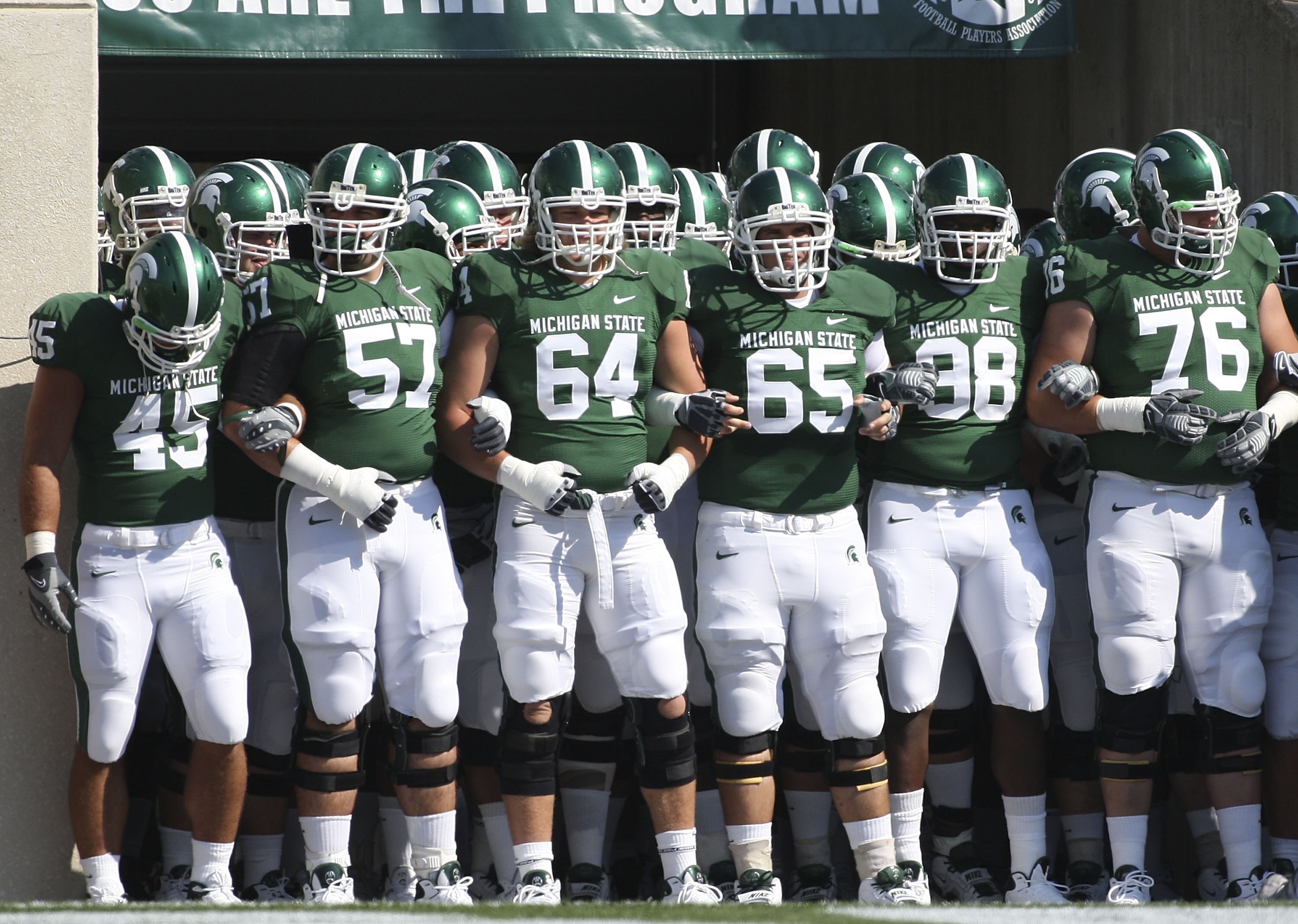 EAST LANSING, MI - SEPTEMBER 05: Brendon Moss #64 and Joe Nitchman #65 lead the Michigan State Spartans onto the field prior to the start of the game against the Montana State Bobcats on September 5, 2009 at Spartan Stadium in East Lansing, Michigan. (Ph EAST LANSING, MI - SEPTEMBER 05: Brendon Moss #64 and Joe Nitchman #65 lead the Michigan State Spartans onto the field prior to the start of the game against the Montana State Bobcats on September 5, 2009 at Spartan Stadium in East Lansing, Michigan. (Ph