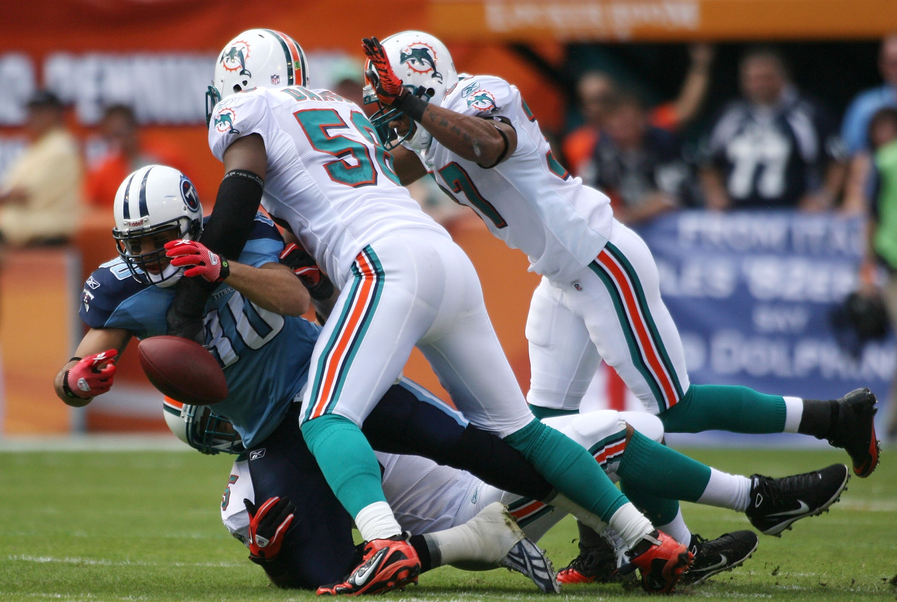 MIAMI - NOVEMBER 14:  Tight end Bo Scaife #80 of the Tennessee Titans fumbles against defenders Karlos Dansby and Yeramiah Bell #37 of the Miami Dolphins at Sun Life Stadium on November 14, 2010 in Miami, Florida.  (Photo by Marc Serota/Getty Images)