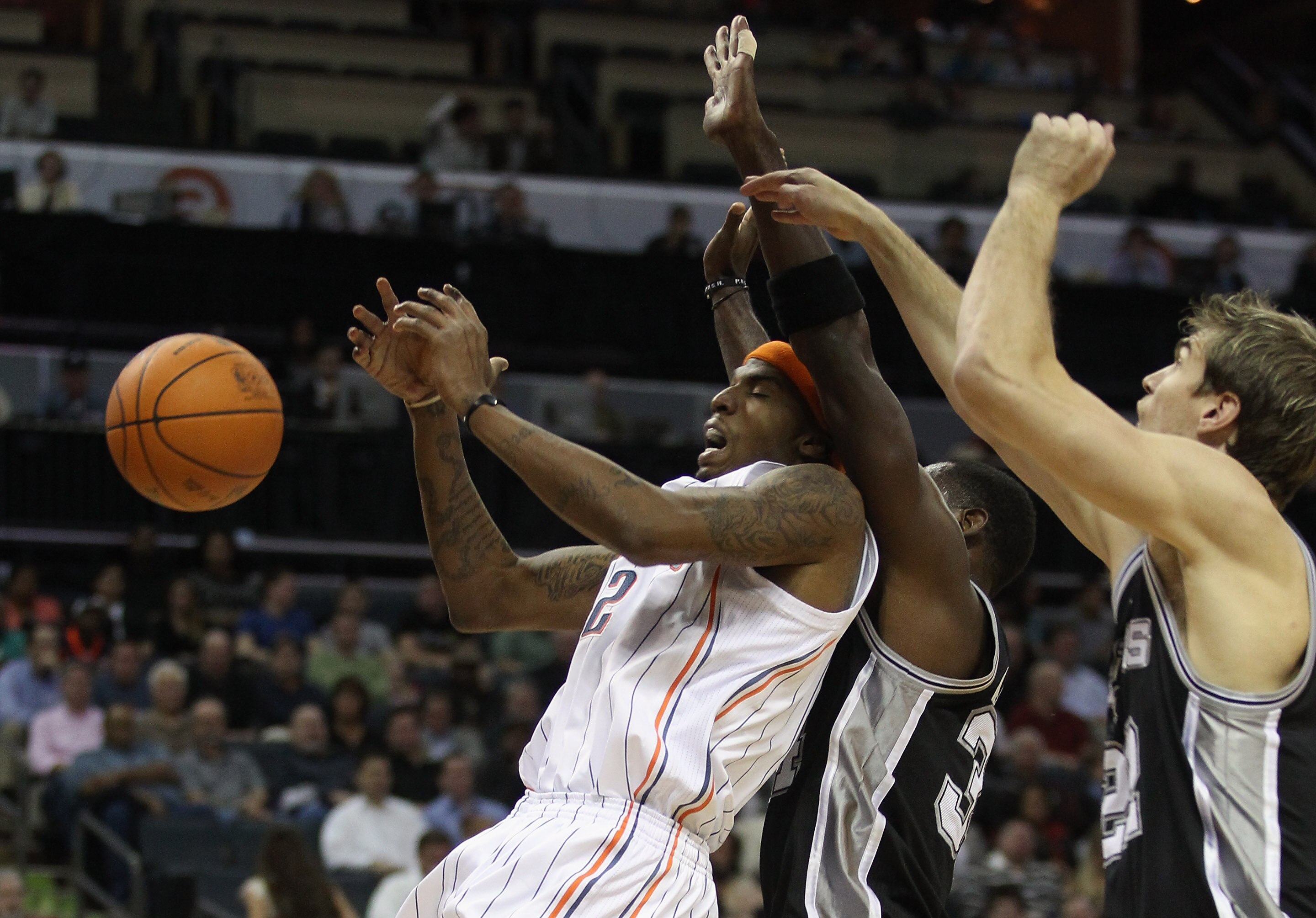 CHARLOTTE, NC - NOVEMBER 08:  Teammates Antonio McDyess #34 and Tiago Splitter #22 of the San Antonio Spurs collide with Tyrus Thomas #12 of the Charlotte Bobcats during their game at Time Warner Cable Arena on November 8, 2010 in Charlotte, North Carolin