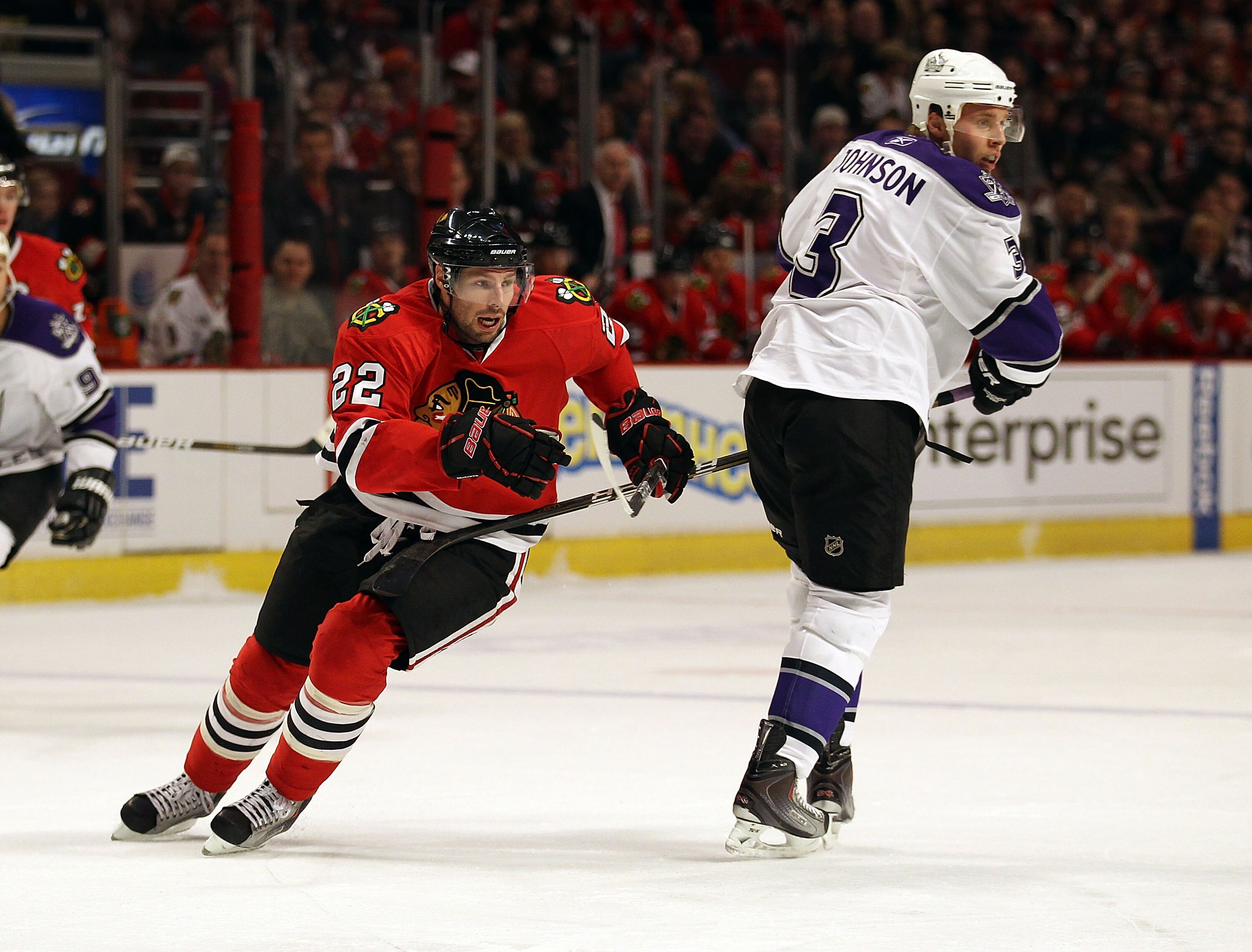 CHICAGO, IL - DECEMBER 19: Troy Brouwer #22 of the Chicago Blackhawks moves to the puck around Jack Johnson #3 of the Los Angeles Kings at the United Center on December 19, 2010 in Chicago, Illinois. The Blackhawks defeated the Kings 3-2.  (Photo by Jonat