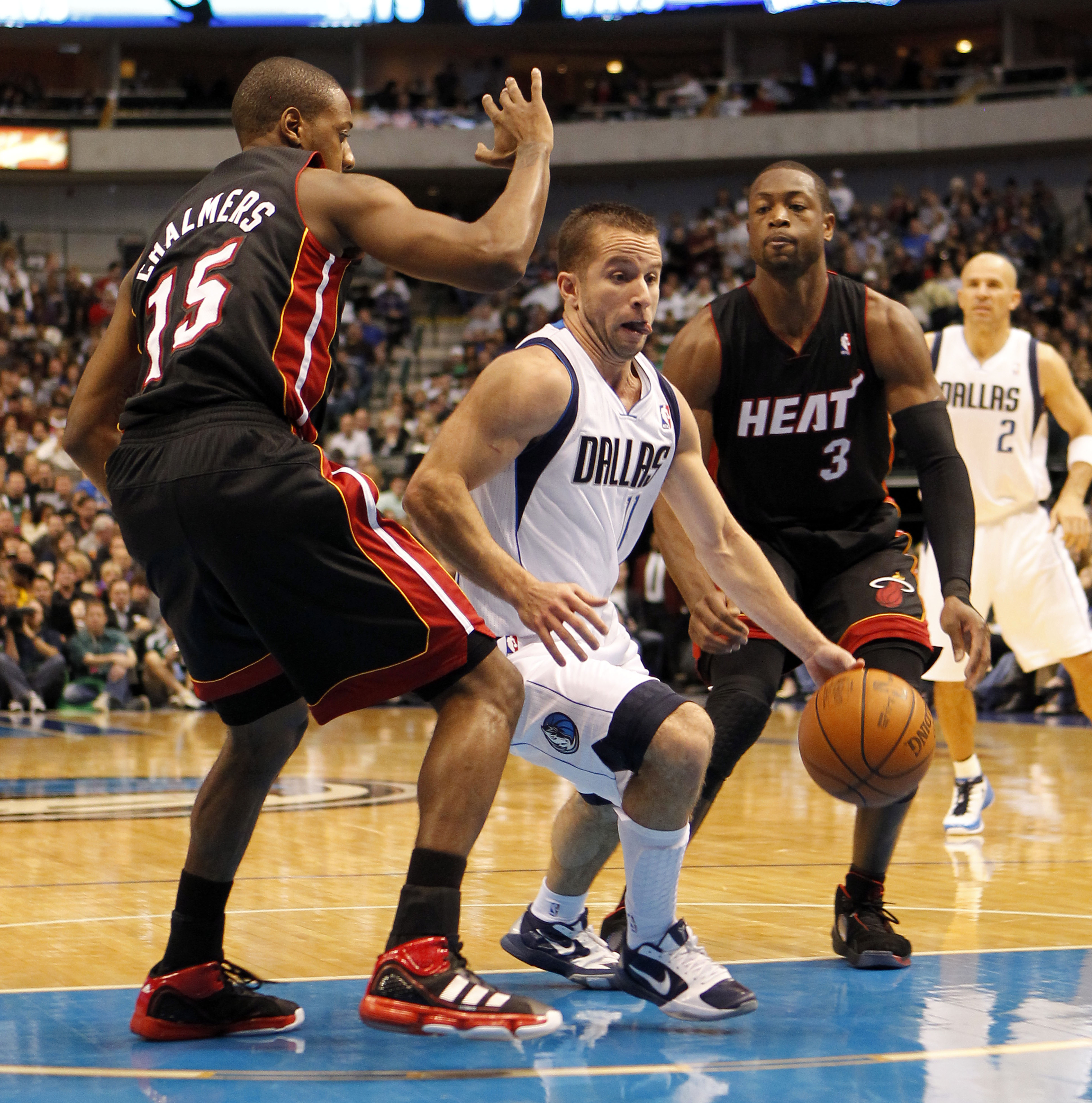 DALLAS - NOVEMBER 27: Jose Barea #11 of the Dallas Mavericks drives between Mario Chalmers #15 and Dwyane Wade #3 of the Miami Heat on November 27, 2010 at the American Airlines Center in Dallas, Texas. NOTE TO USER: User expressly acknowledges and agrees