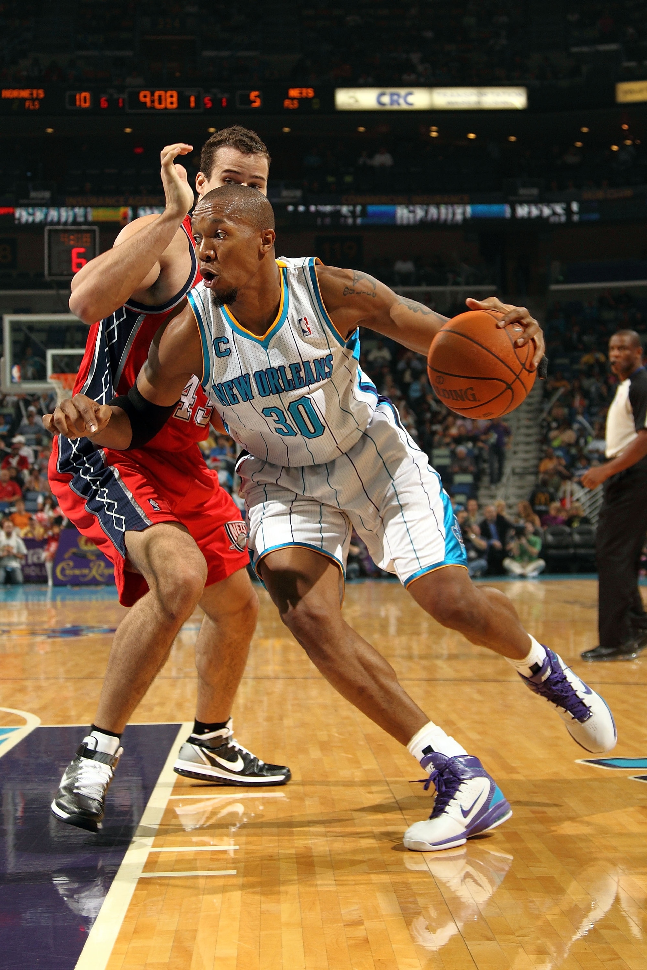 NEW ORLEANS, LA - DECEMBER 22: David West #30  of the New Orleans Hornets drives the ball around Kris Humphries #43 of the New Jersey Nets at the New Orleans Arena on December 22, 2010 in New Orleans, Louisiana.  The Hornets defeated the Nets 105-91.   NO