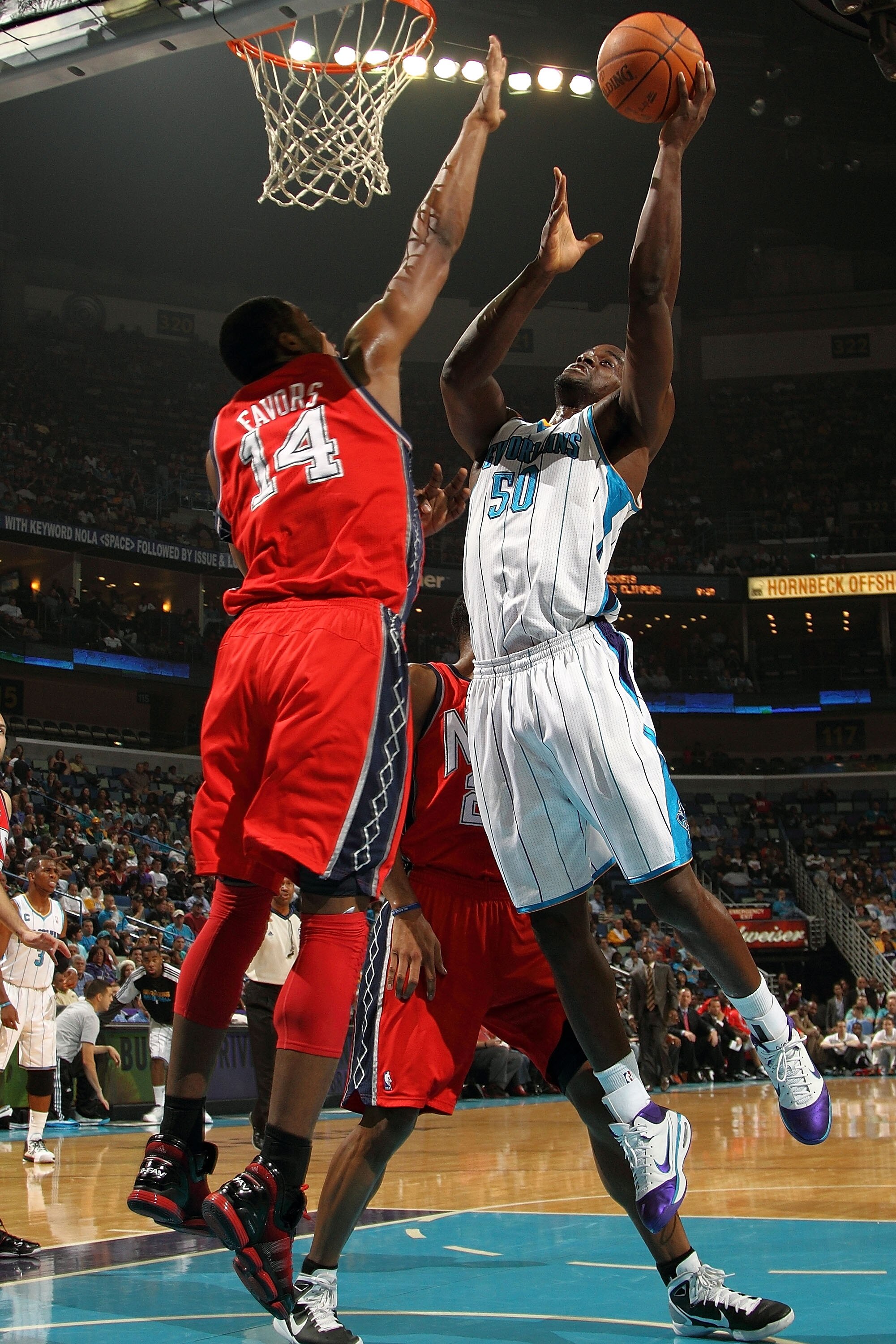 NEW ORLEANS, LA - DECEMBER 22:  Emeka Okafor #50 of the New Orleans Hornets shoots the ball over Derrick Favors #14 of the New Jersey Nets at the New Orleans Arena on December 22, 2010 in New Orleans, Louisiana.   NOTE TO USER: User expressly acknowledges
