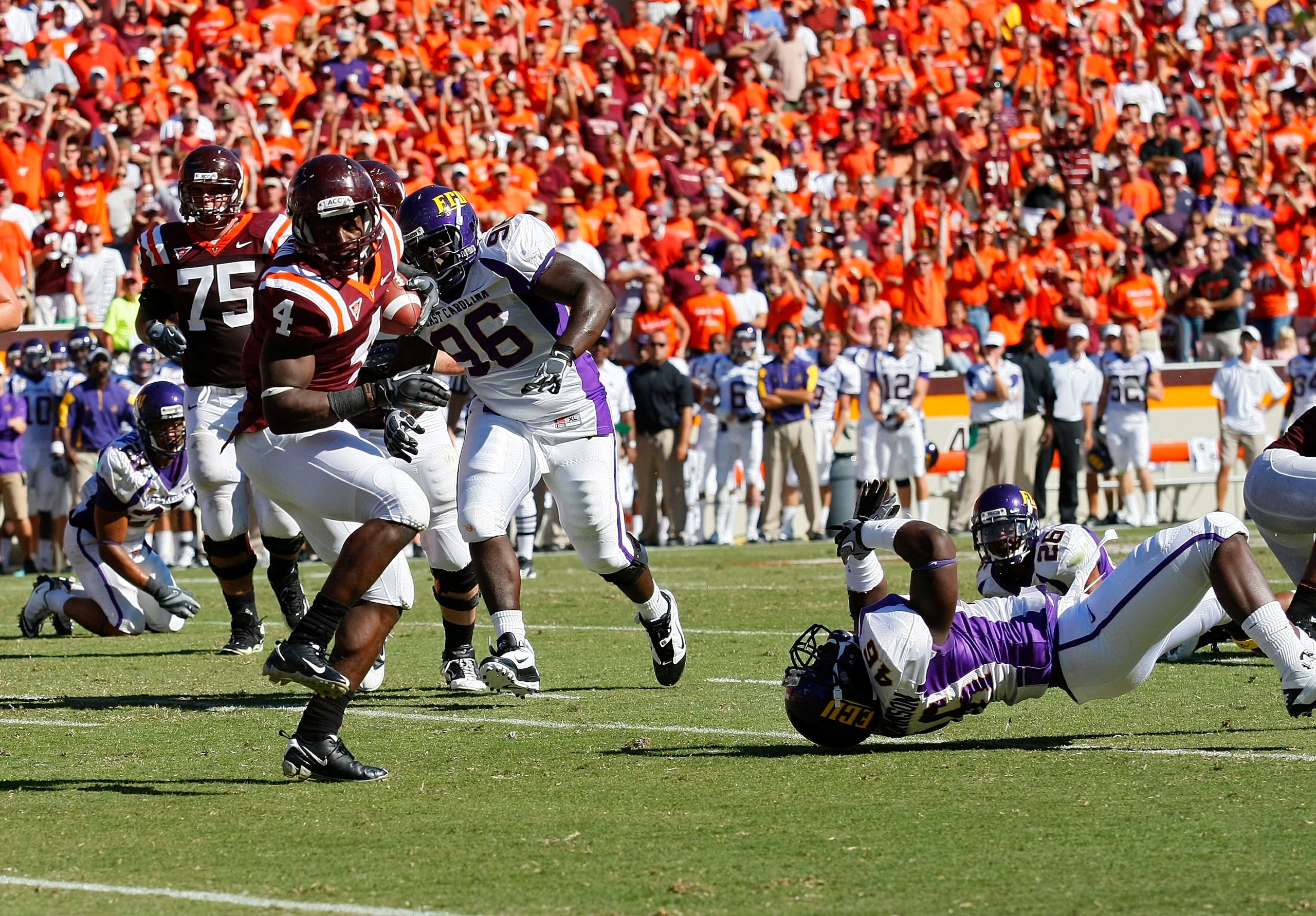 BLACKSBURG, VA - SEPTEMBER 18: Running back David Wilson #4 of the Virginia Tech Hokies avoids the tackle of  defensive tackle A.J. Johnson #46 of the East Carolina Pirates to score a touchdown at Lane Stadium on September 18, 2010 in Blacksburg, Virginia