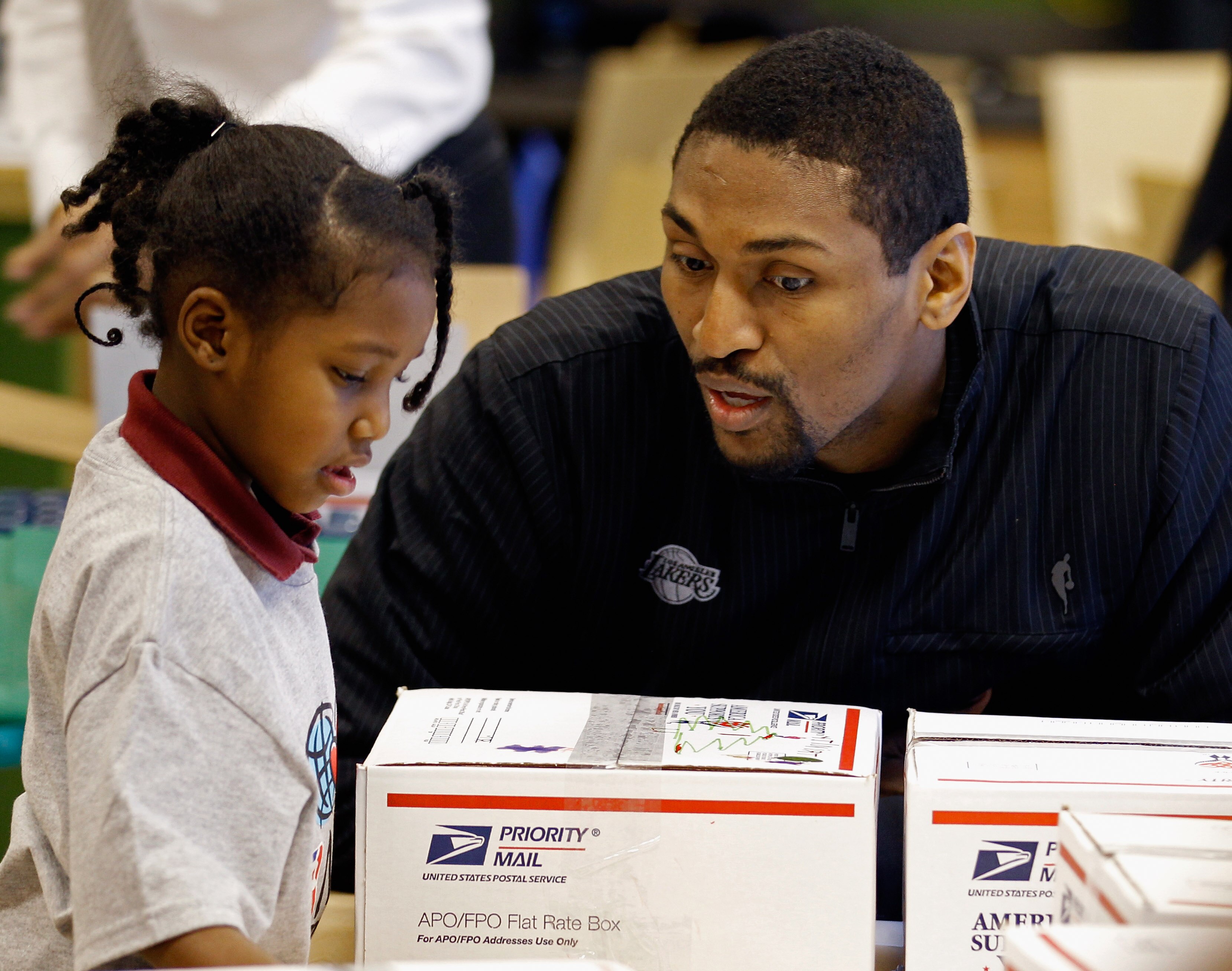 WASHINGTON, DC - DECEMBER 13:  (AFP OUT) Los Angeles Lakers forward Ron Artest (R) helps children volunteers fill care packages during a NBA Cares service event at the Boys and Girls Club at THEARC   December 13, 2010 in Washington, DC. Bryant and all the