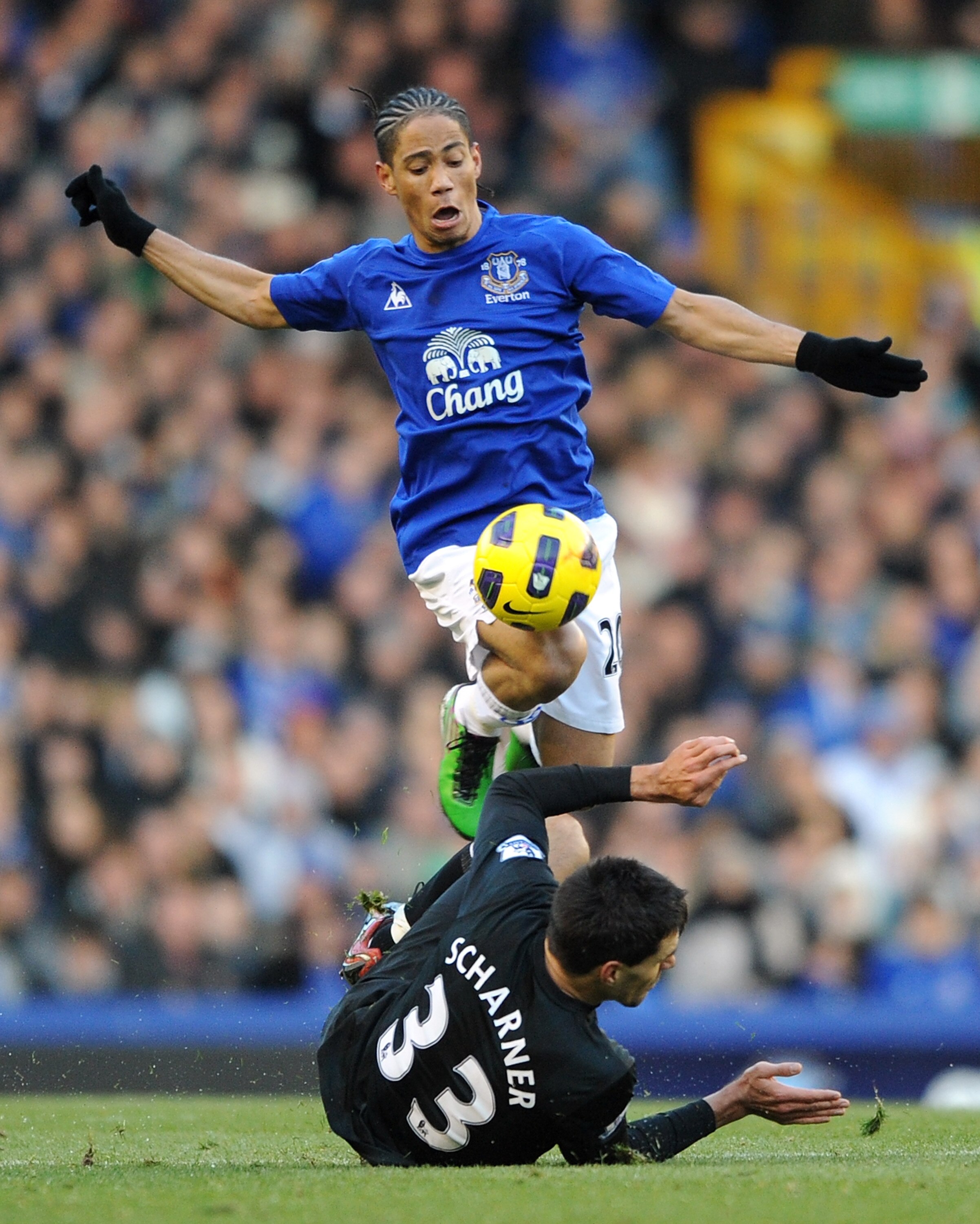 LIVERPOOL, ENGLAND - NOVEMBER 27:  Steven Pienaar of Everton hurdles the challenge of Paul Scharner of West Bromwich Albion during the Barclays Premier League match between Everton and West Bromwich Albion at Goodison Park on November 27, 2010 in Liverpoo