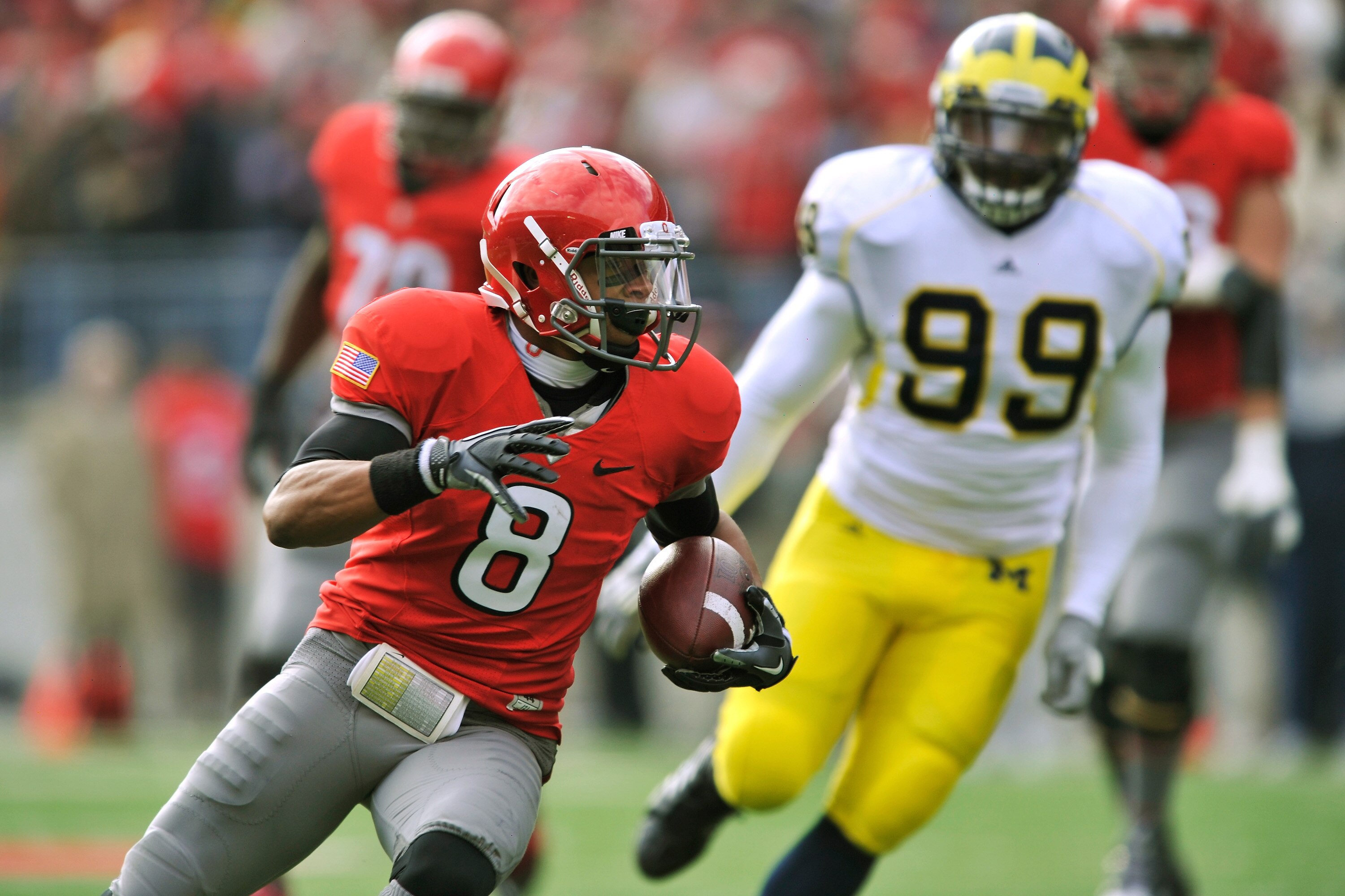 COLUMBUS, OH - NOVEMBER 27:  DeVier Posey #8 of the Ohio State Buckeyes heads for the endzone on a 33-yard touchdown reception in the second quarter as Adam Patterson #99 of the Michigan Wolverines pursues at Ohio Stadium on November 27, 2010 in Columbus,