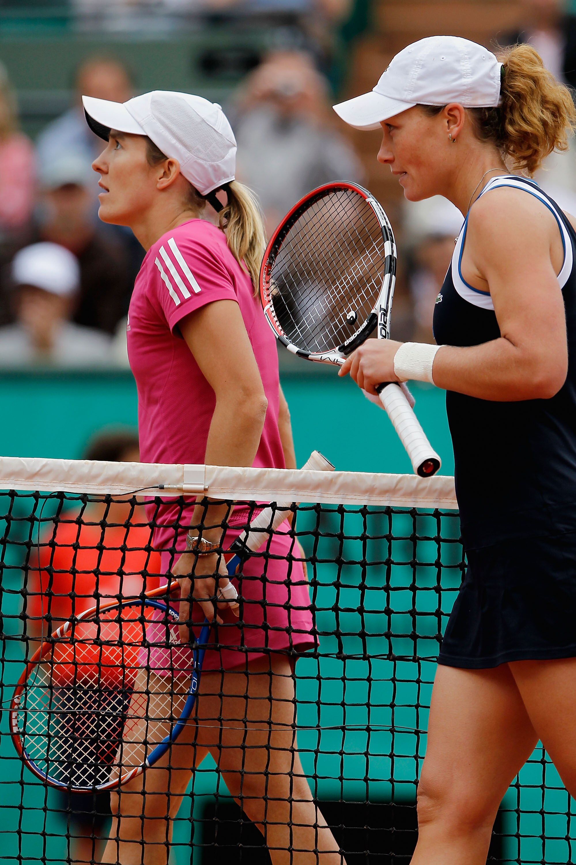 PARIS - MAY 31:  Samantha Stosur of Australia walks off with with Justine Henin of Belgium after winning the women's singles fourth round match between Justine Henin of Belgium and Samantha Stosur of Australia on day nine of the French Open at Roland Garr