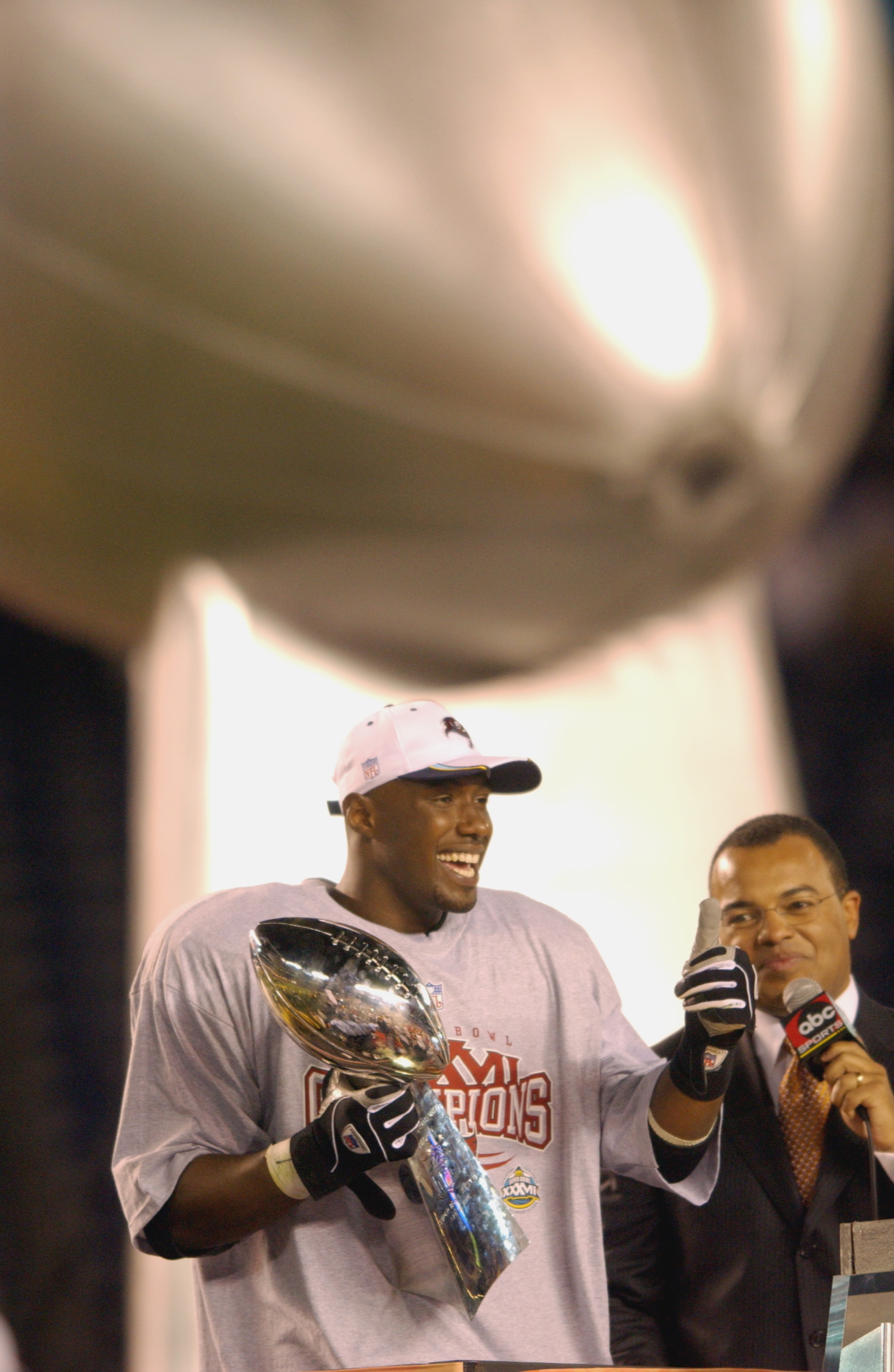 SAN DIEGO - JANUARY 26:  Super Bowl MVP Dexter Jackson #34 of the Tampa Bay Buccaneers gives a thumbs up from the victory stage as he holds the Vince Lombardi Trophy while wearing his Super Bowl Champions tee shirt and cap as ABC Sports commentator Mike T