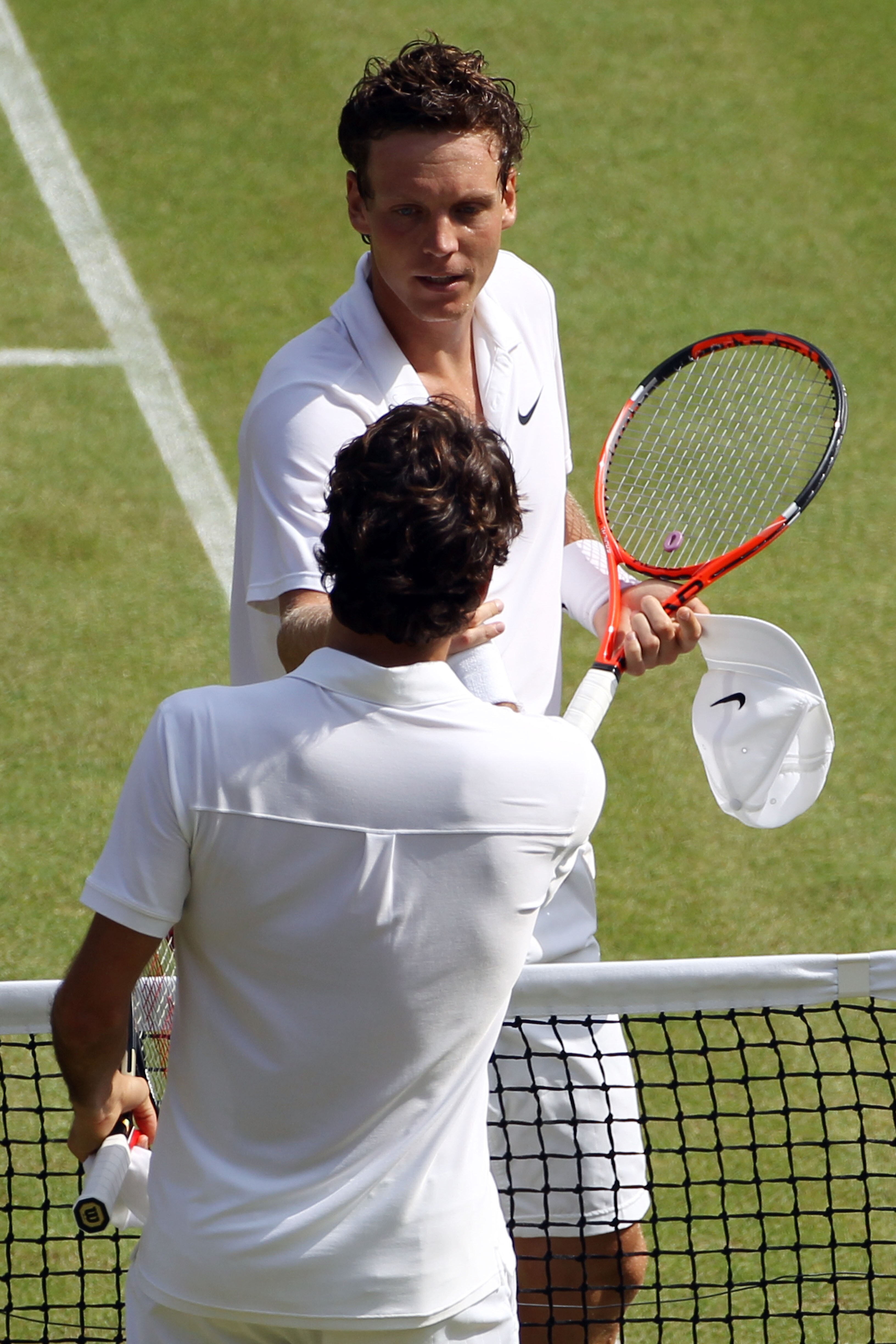 LONDON, ENGLAND - JUNE 30:  Tomas Berdych of Czech Republic (top) shakes hands after winning his Quarter Final match against Roger Federer of Switzerland on Day Nine of the Wimbledon Lawn Tennis Championships at the All England Lawn Tennis and Croquet Clu