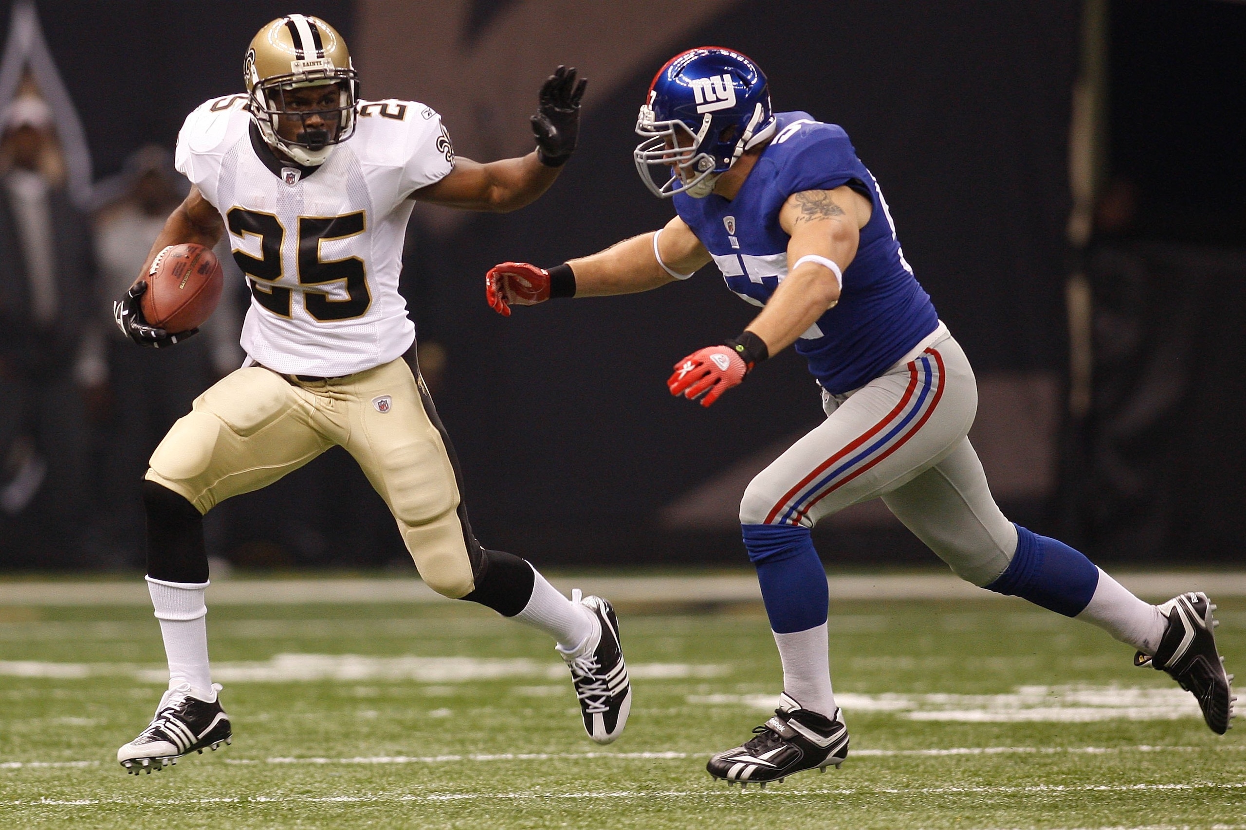 NEW ORLEANS - OCTOBER 18:  Reggie Bush #25 of the New Orleans Saints escapes a tackle by Chase Blackburn #57 of the New York Giants at the Louisiana Superdome on October 18, 2009 in New Orleans, Louisiana.  (Photo by Chris Graythen/Getty Images)