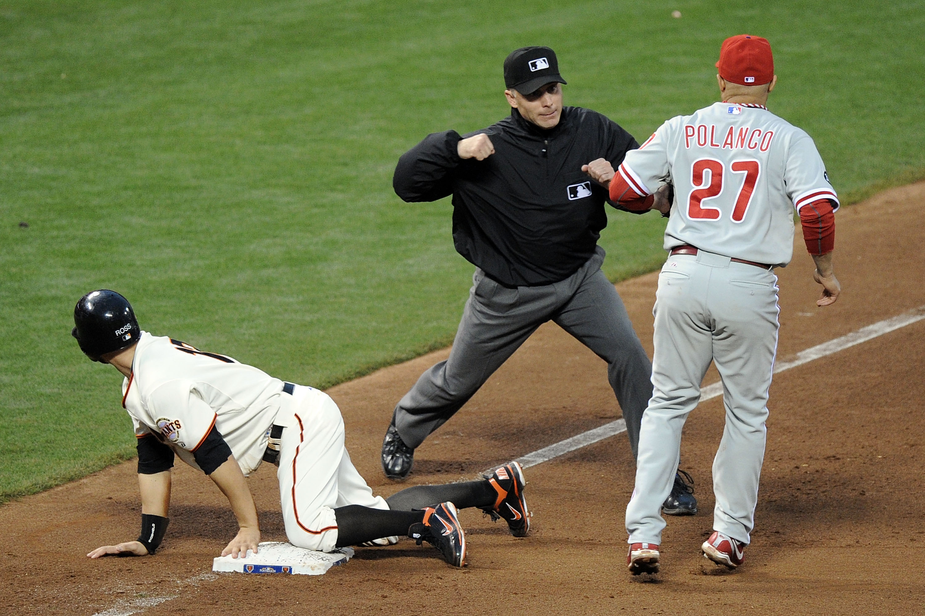 SAN FRANCISCO - OCTOBER 21:  Umpire Dan Iassogna calls out Cody Ross #13 of the San Francisco Giants as he is tagged by Placido Polanco #27 of the Philadelphia Phillies in the fourth inning in Game Five of the NLCS during the 2010 MLB Playoffs at AT&T Par