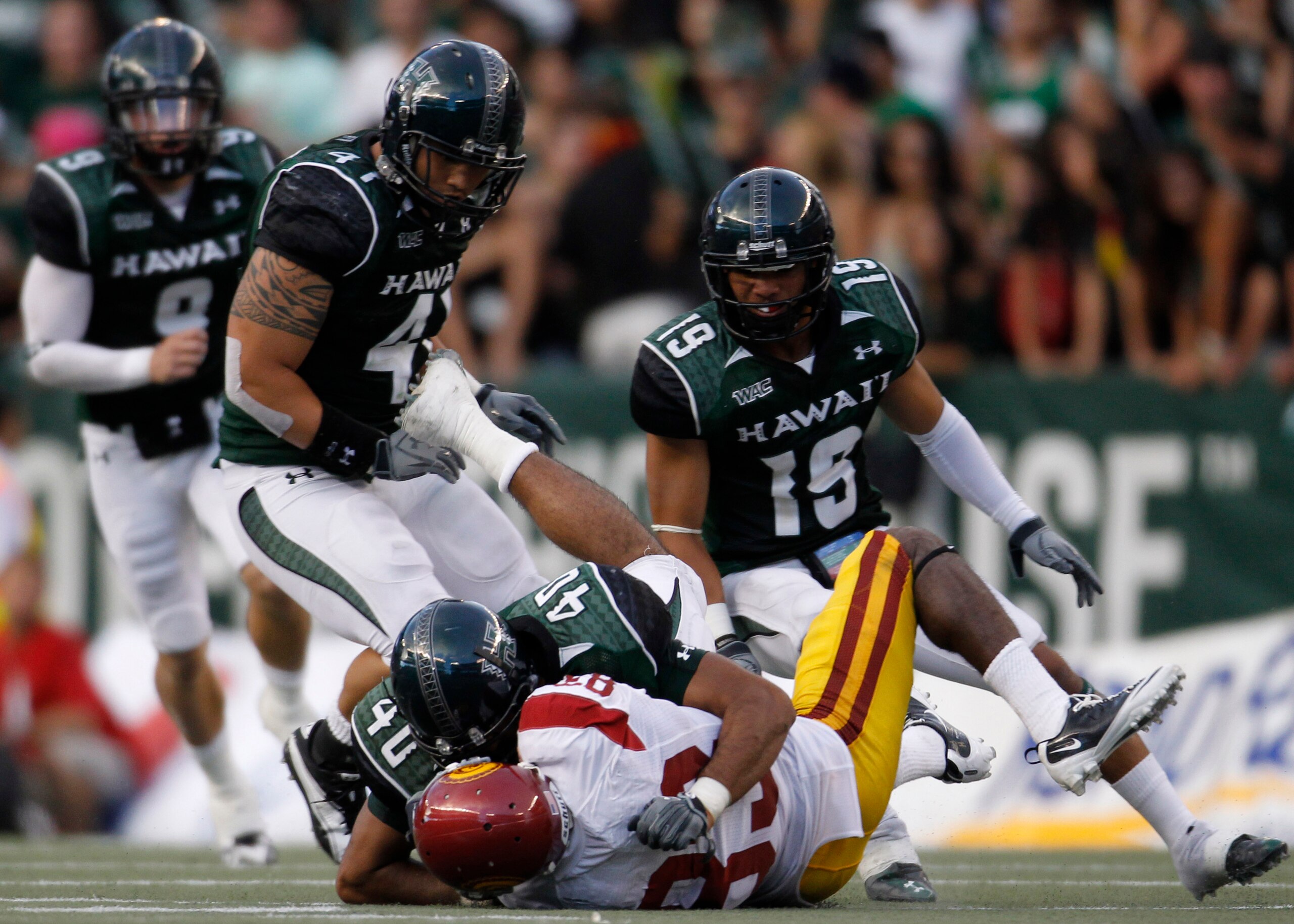 HONOLULU - SEPTEMBER 02: Ronald Johnson #83 of the University of Southern California Trojans is taken down by Po'okela Ahmad #40 of the University of Hawaii Warriors during first half action against the University of Southern California Trojans at Aloha S HONOLULU - SEPTEMBER 02: Ronald Johnson #83 of the University of Southern California Trojans is taken down by Po'okela Ahmad #40 of the University of Hawaii Warriors during first half action against the University of Southern California Trojans at Aloha S